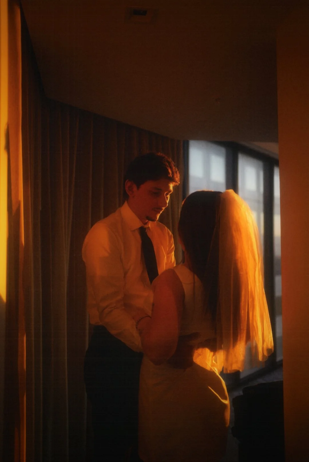 An intimate moment between the couple in Houston, Texas, framed by warm window light and quiet connection.