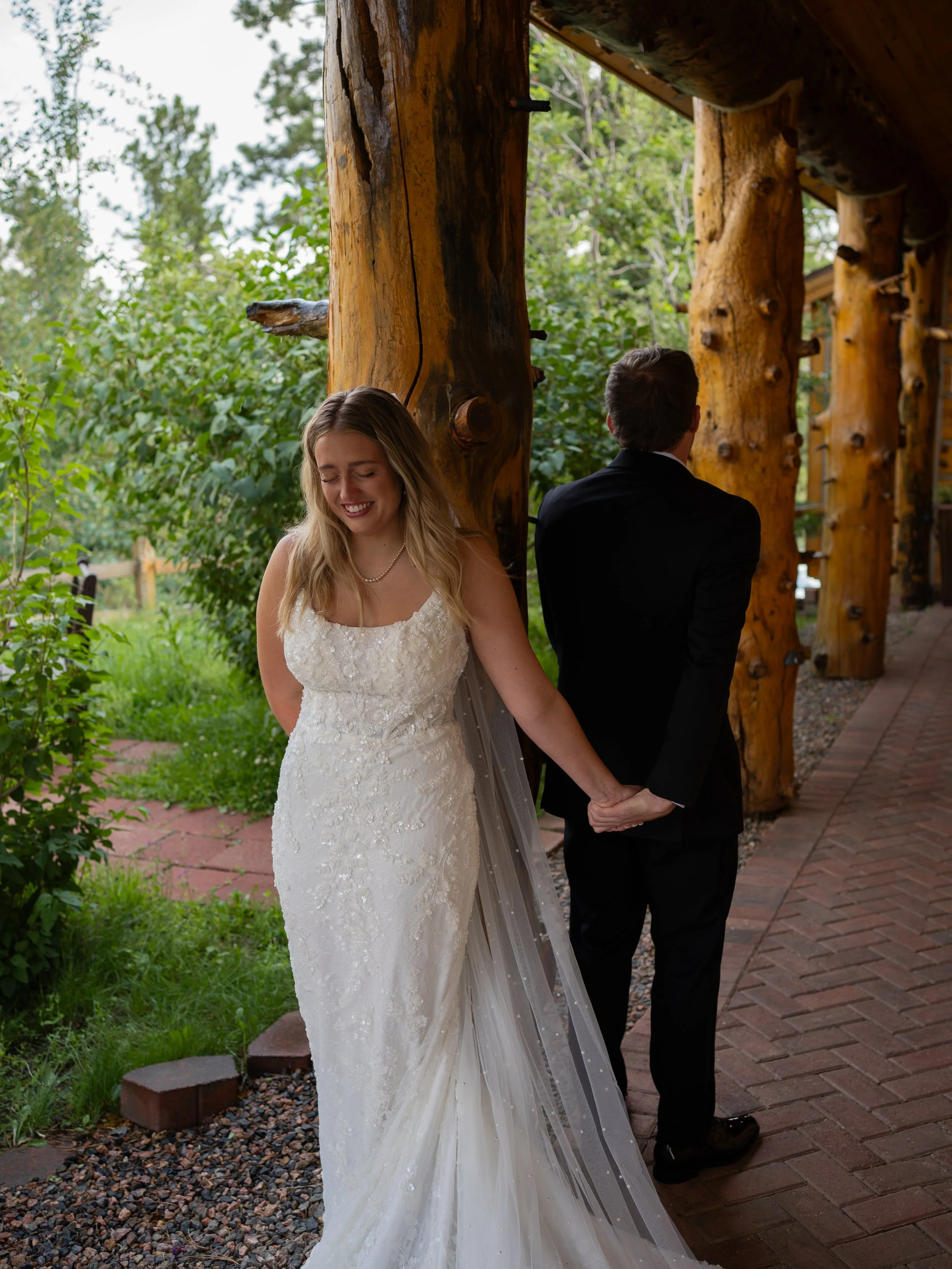 A relaxed and intimate couple’s moment during first touch and private vows in Woodland Park, CO, framed by rustic architecture and natural surroundings.