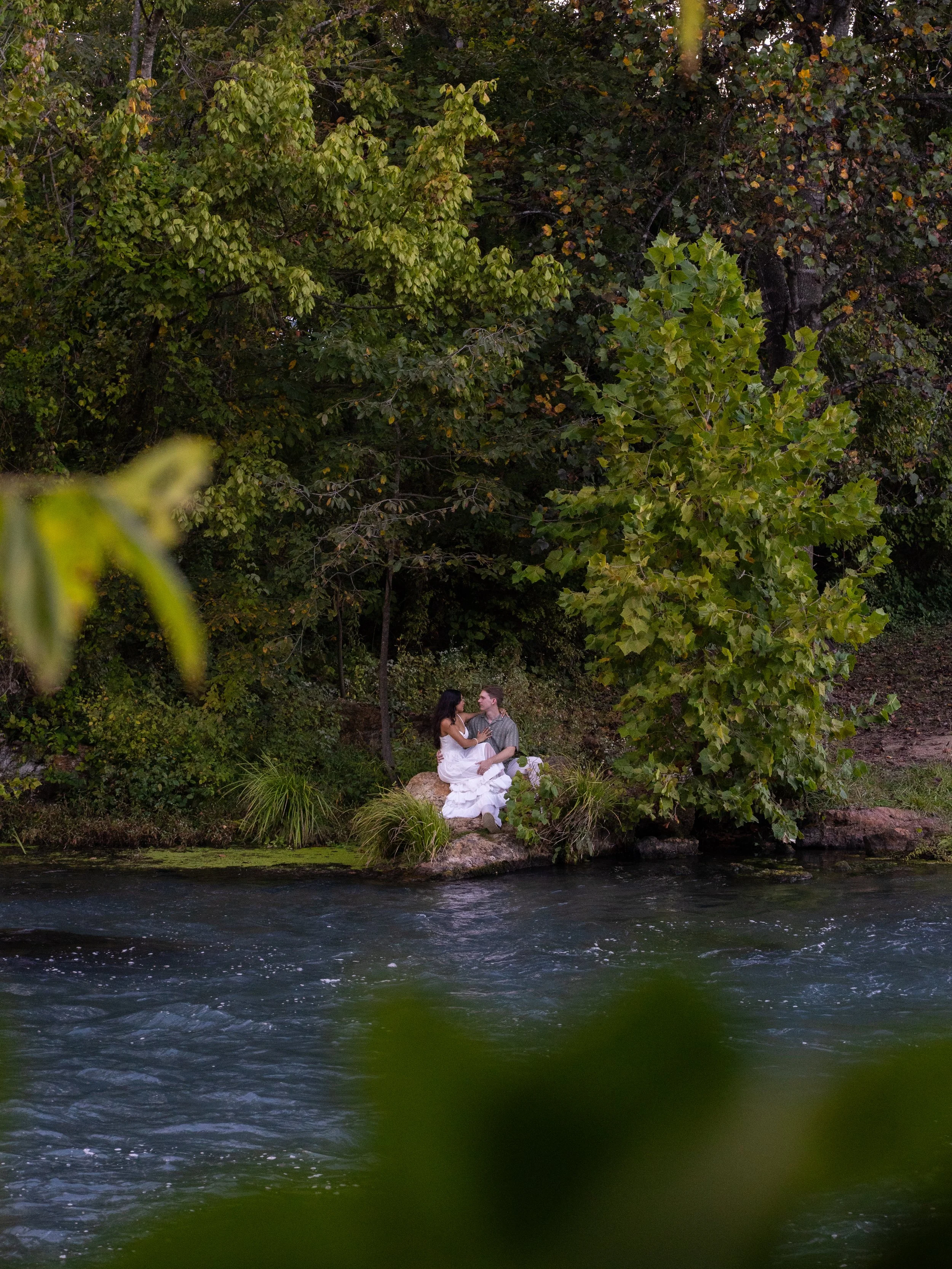 A quiet and intimate riverside portrait in Mammoth Springs, AR, framed by natural elements for a layered, organic feel.