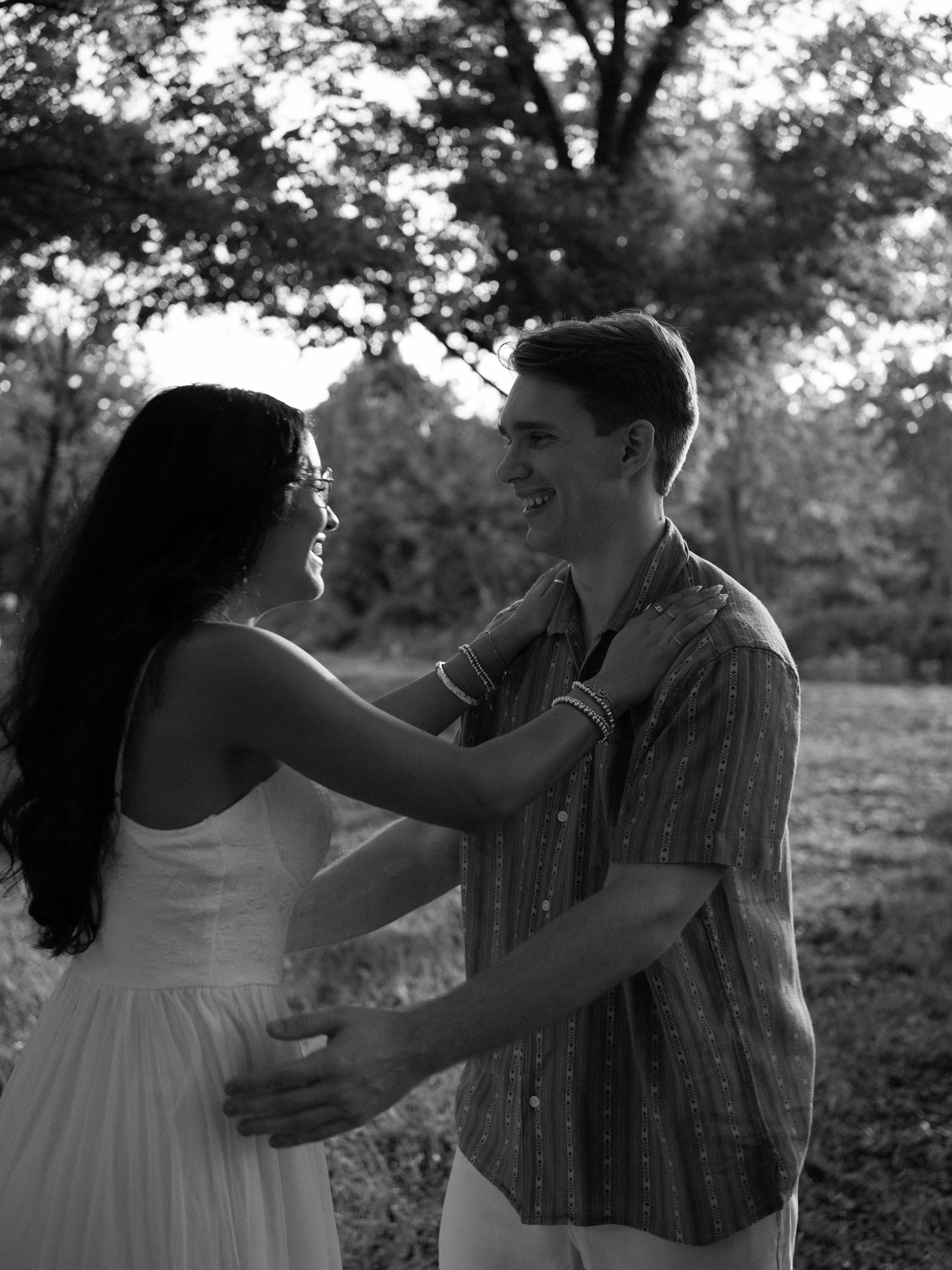 An intimate black-and-white portrait in Mammoth Springs, AR, highlighting genuine connection and quiet laughter.