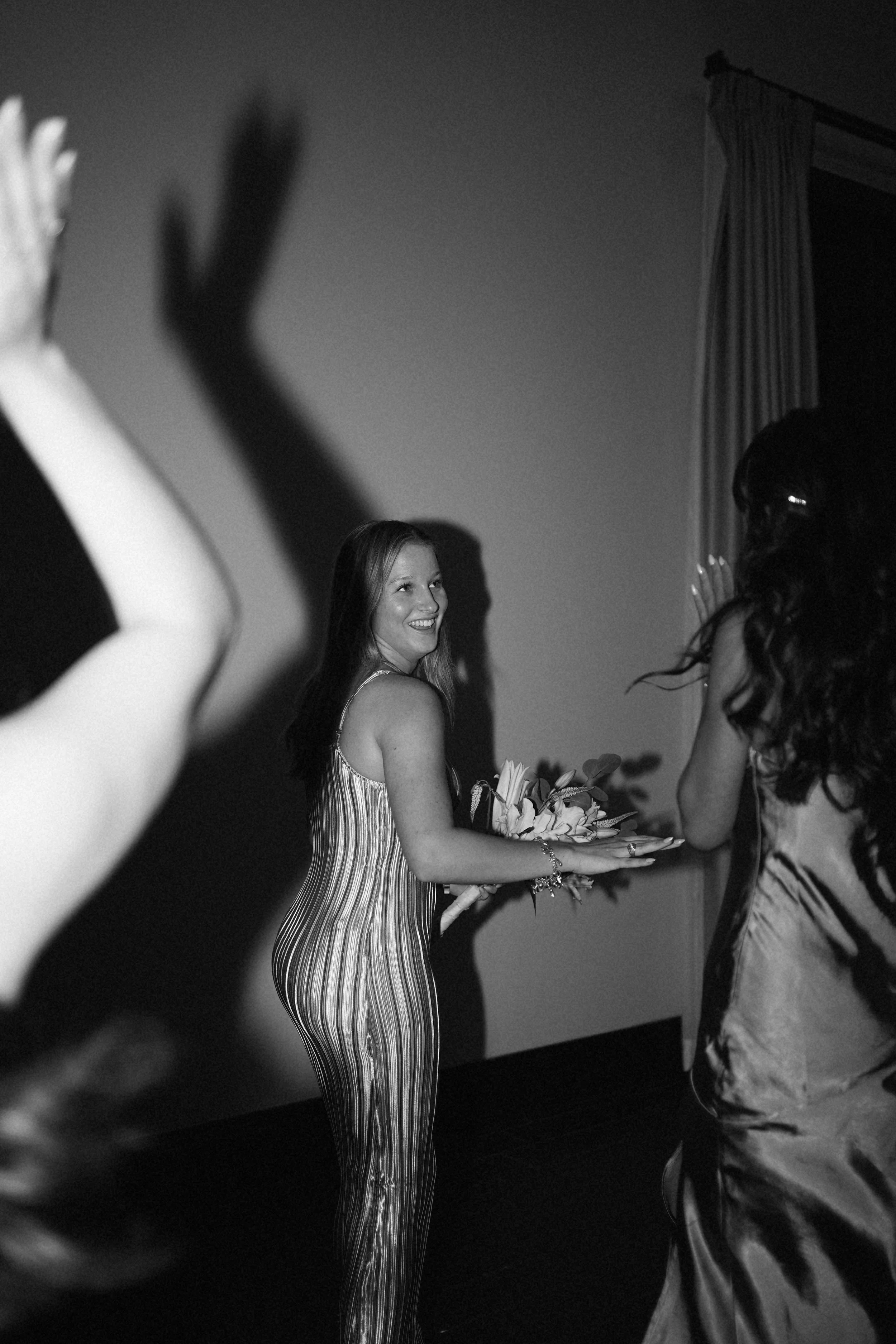 A candid black-and-white reception moment in Richmond, TX, capturing movement and celebration on the dance floor.