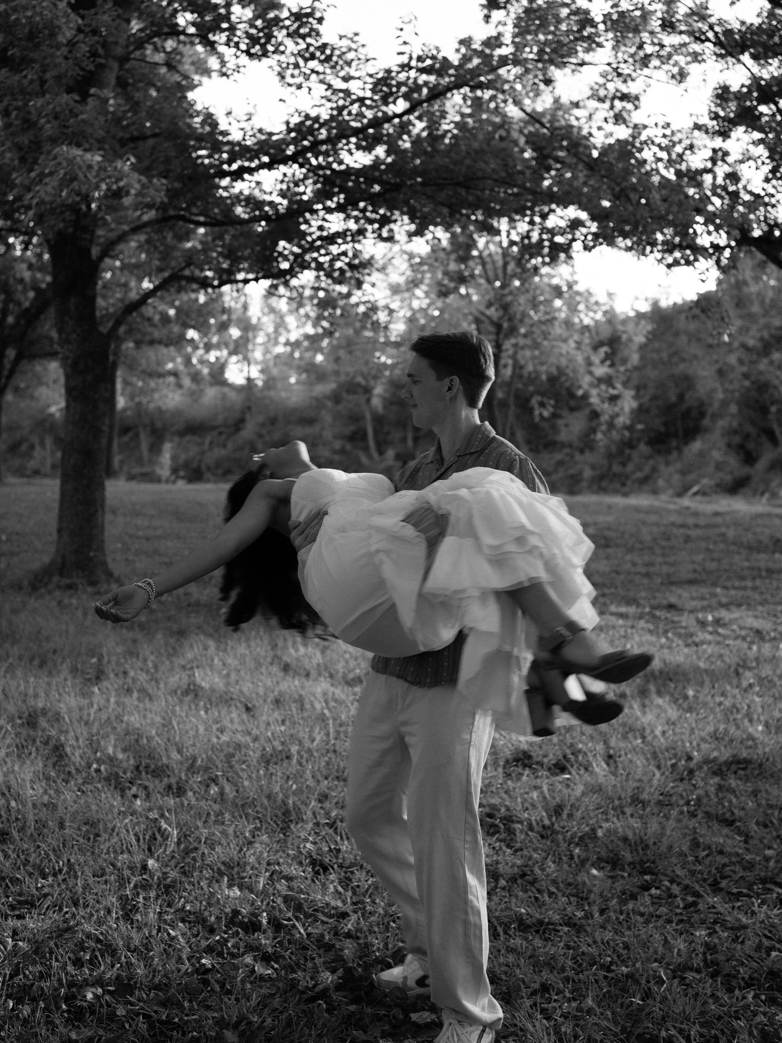 A playful black-and-white moment in Mammoth Springs, AR, as the couple embraces with movement and joy.