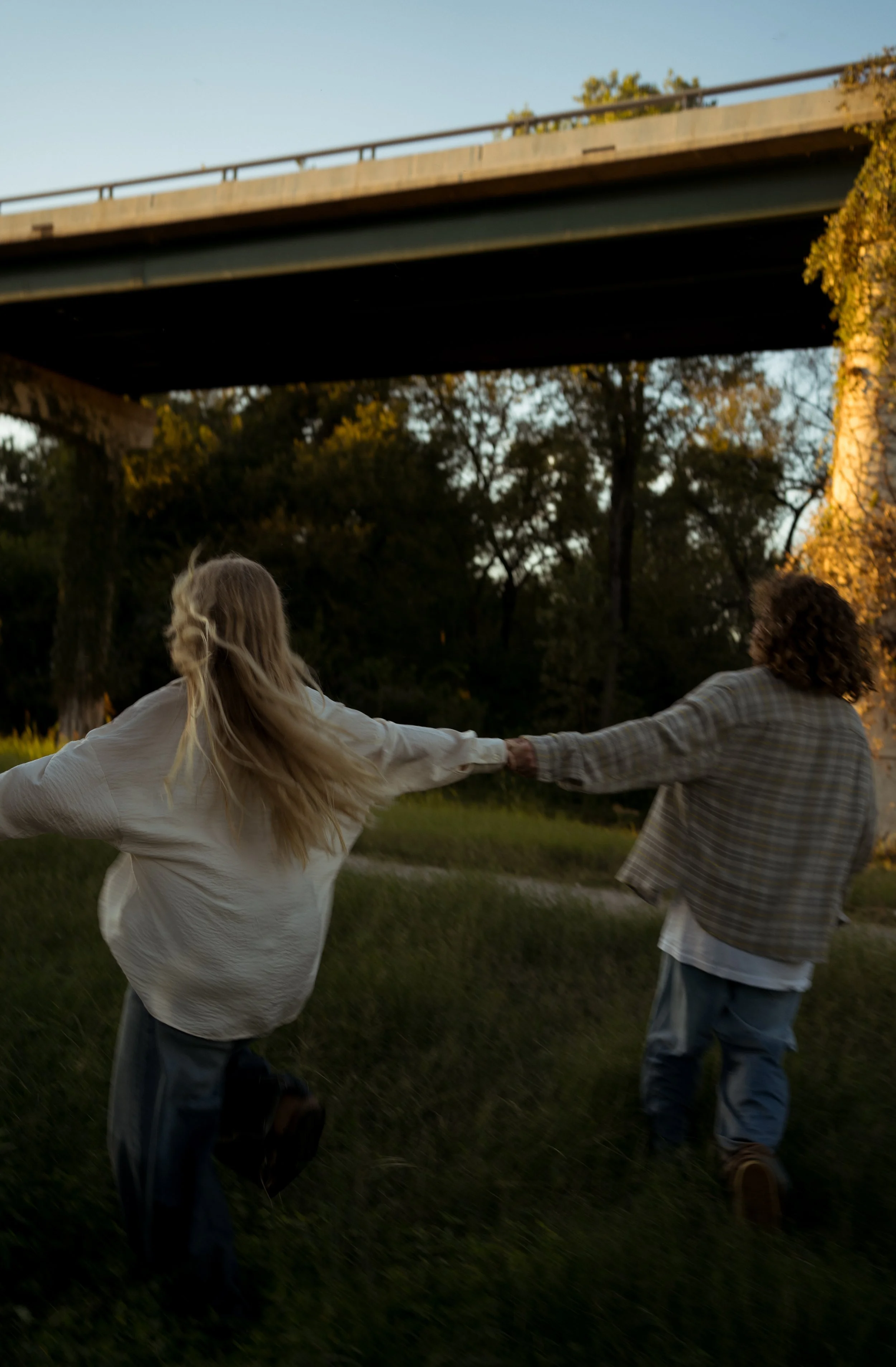 A playful and carefree moment in Rainbow, TX, capturing movement and joy as the couple runs hand in hand.