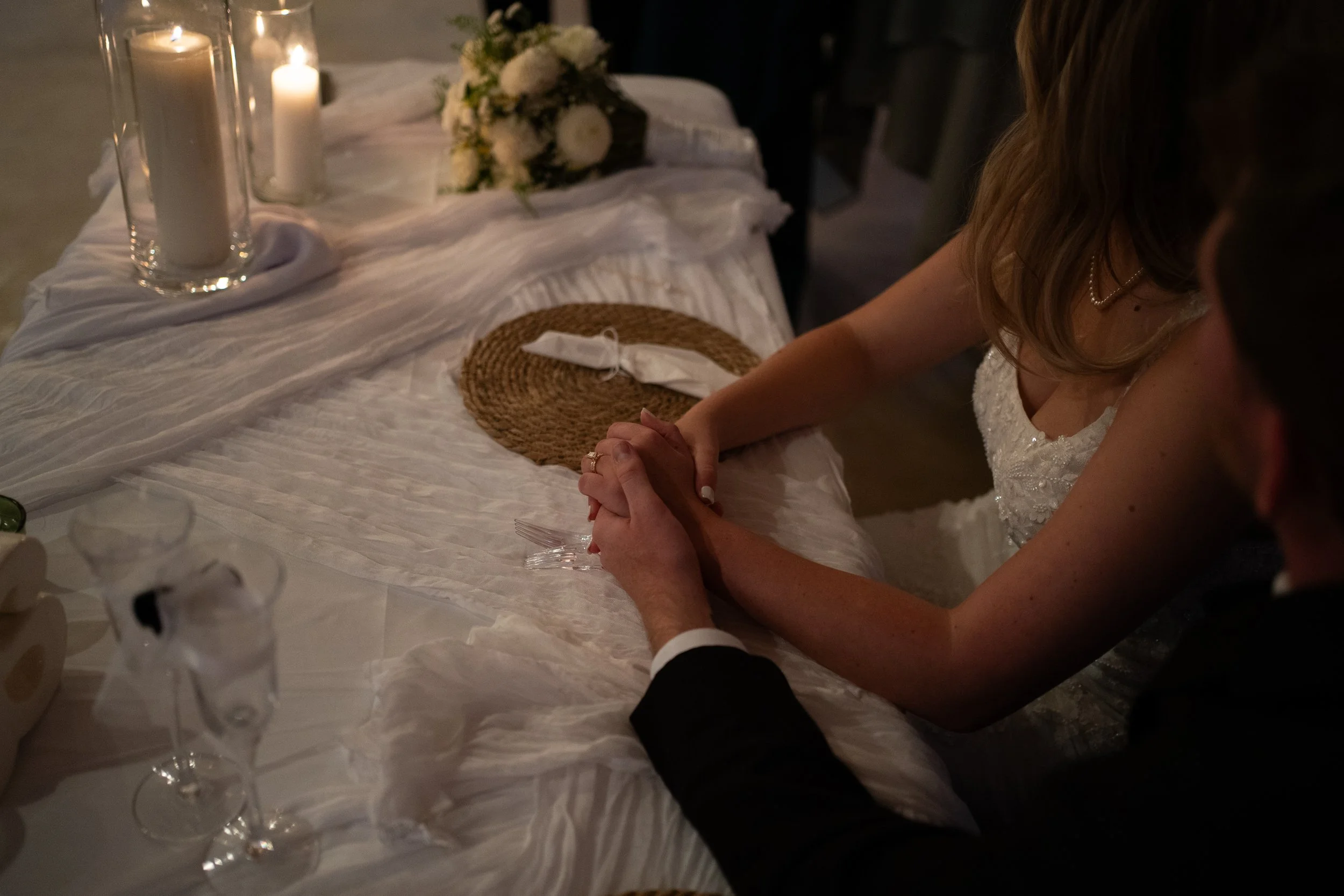 A intimate candlelit reception moment at Pikes Peak Ranch in Woodland Park, Colorado, capturing connection through soft detail and candlelight.