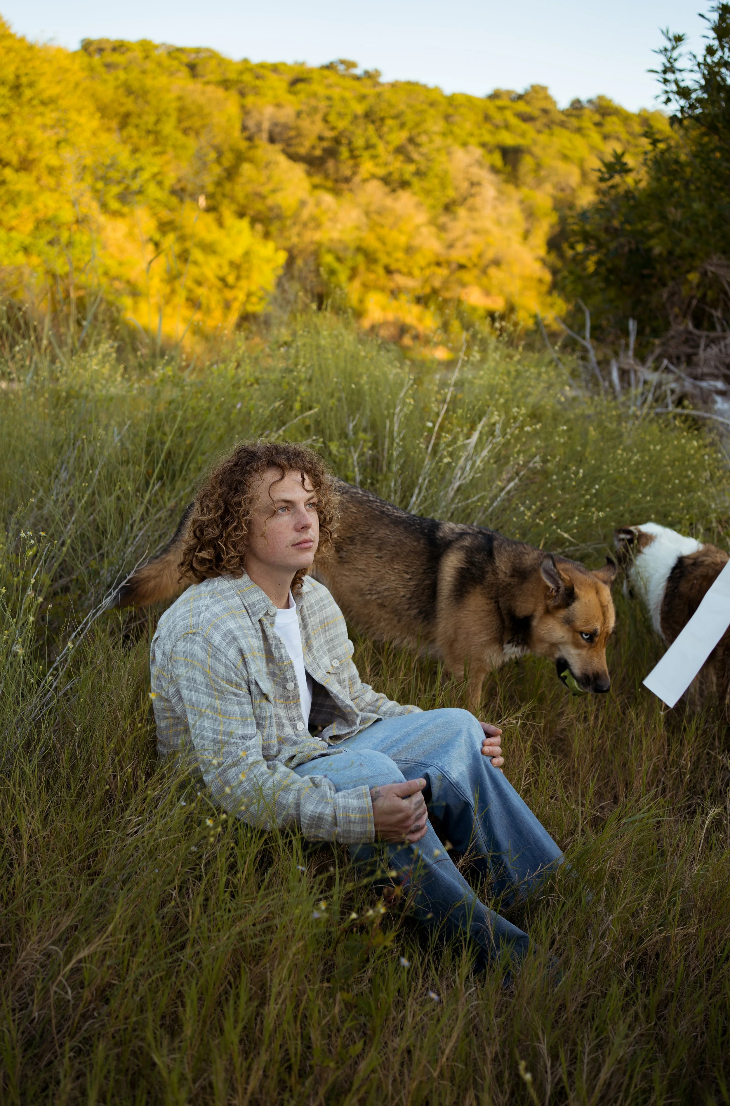 A relaxed and personal moment in Rainbow, TX, capturing the couple with their dogs in a natural setting.