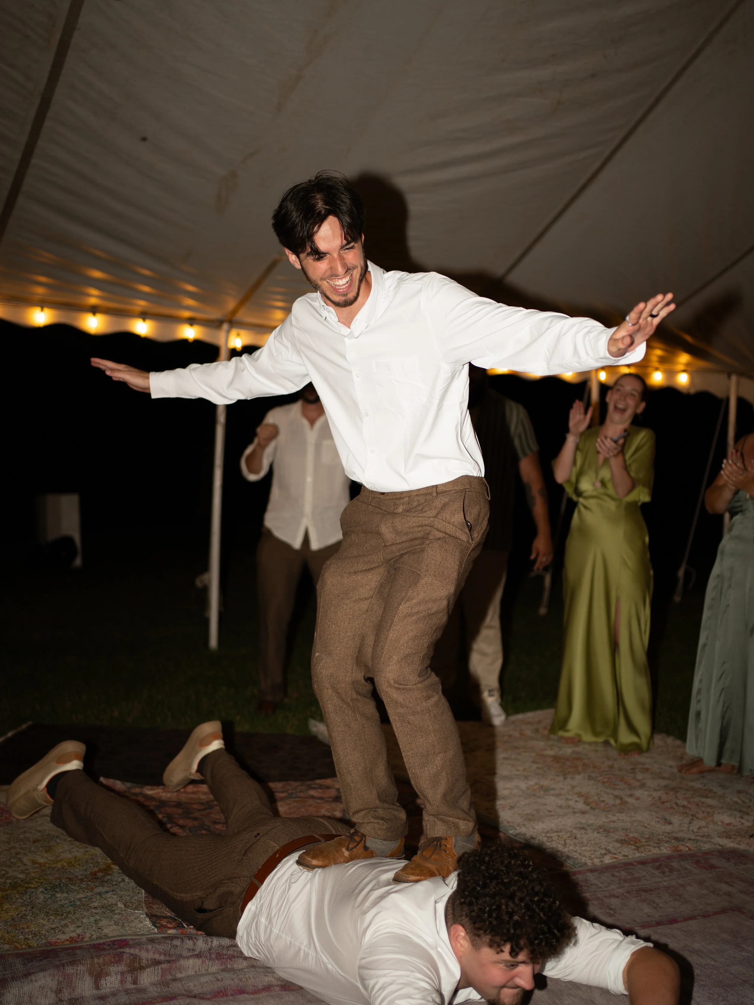 Best man and groom dancing at outdoor wedding reception