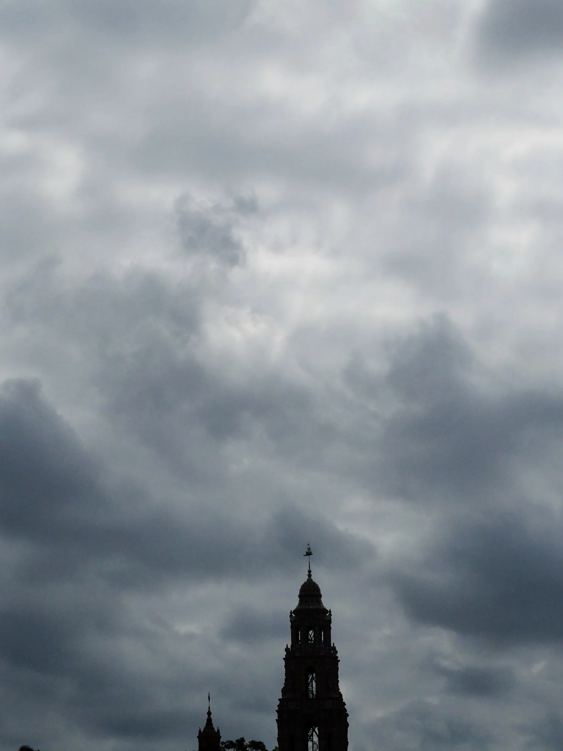 A tall tower with ornate architecture against a cloudy, overcast sky.