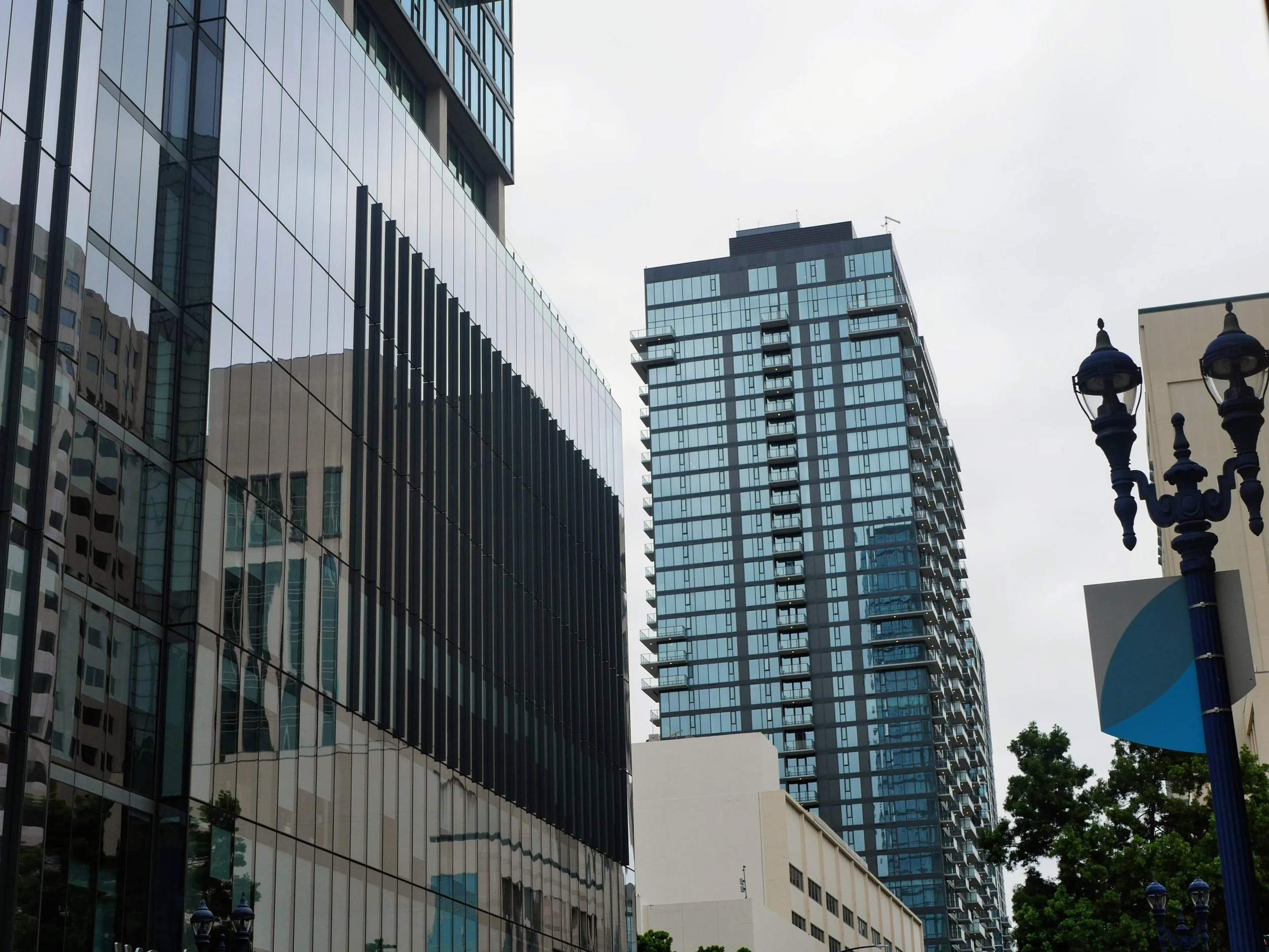Group of modern high-rise office buildings with reflective glass windows and a streetlamp in the foreground.