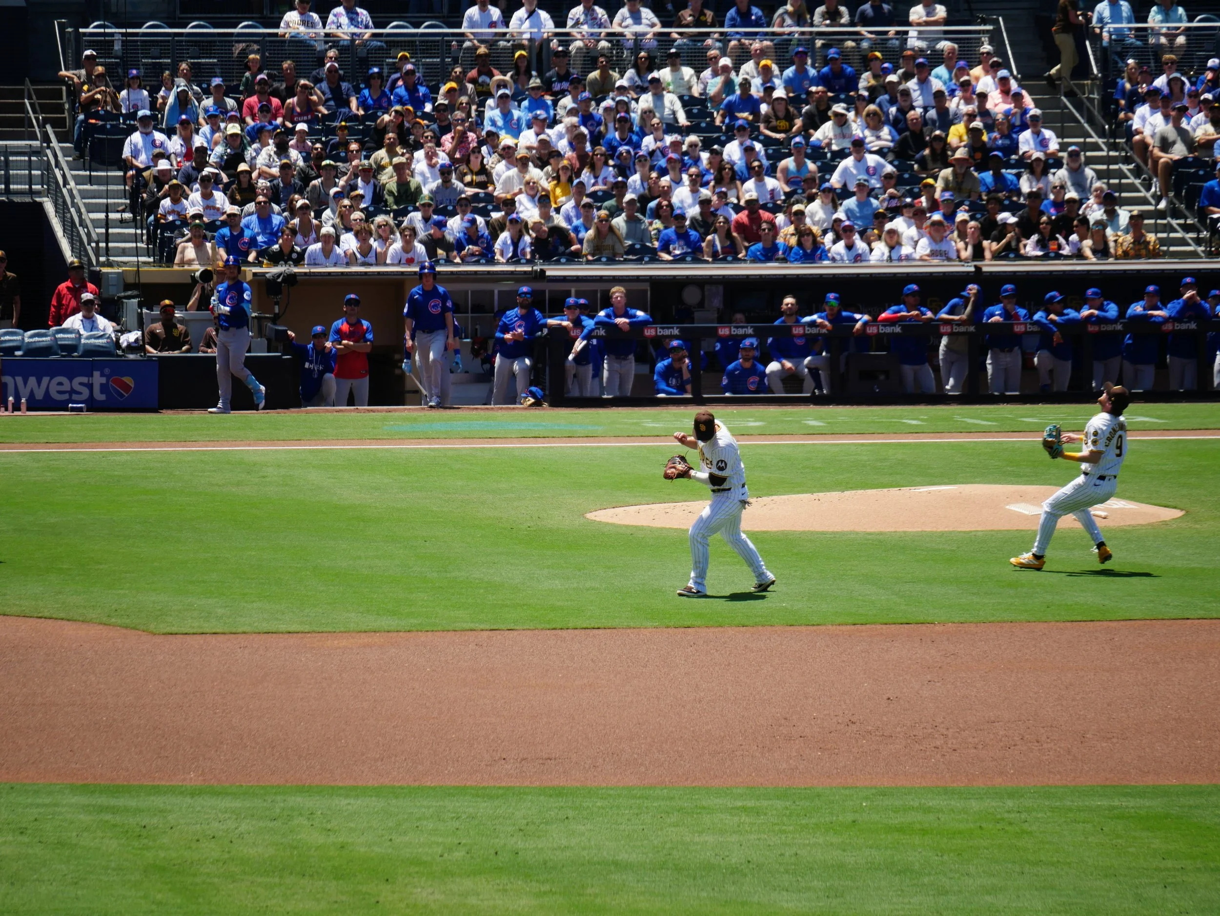 Baseball game with players on the field and spectators in the stands.