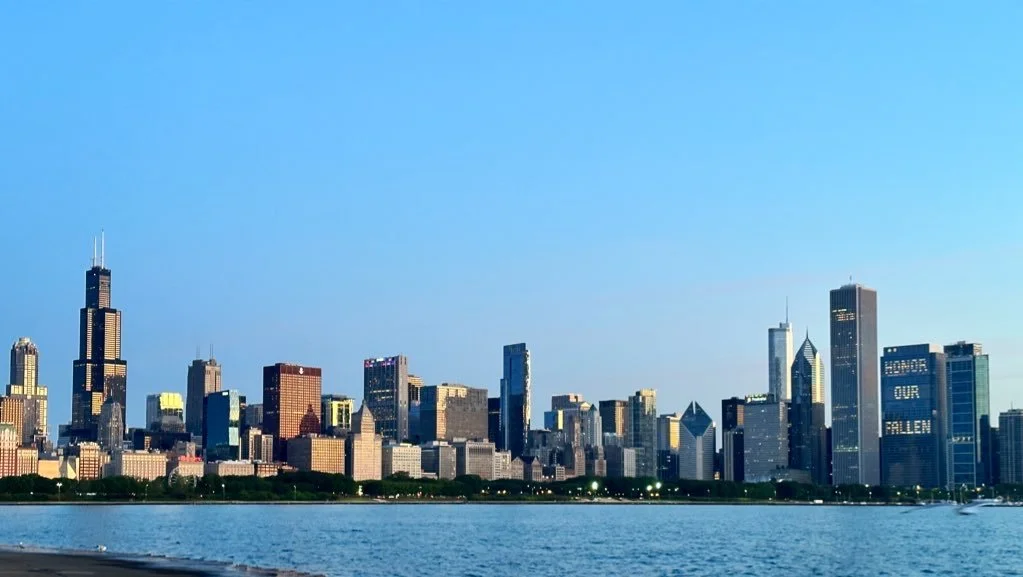 Skyline of Chicago with tall skyscrapers across Lake Michigan, clear blue sky