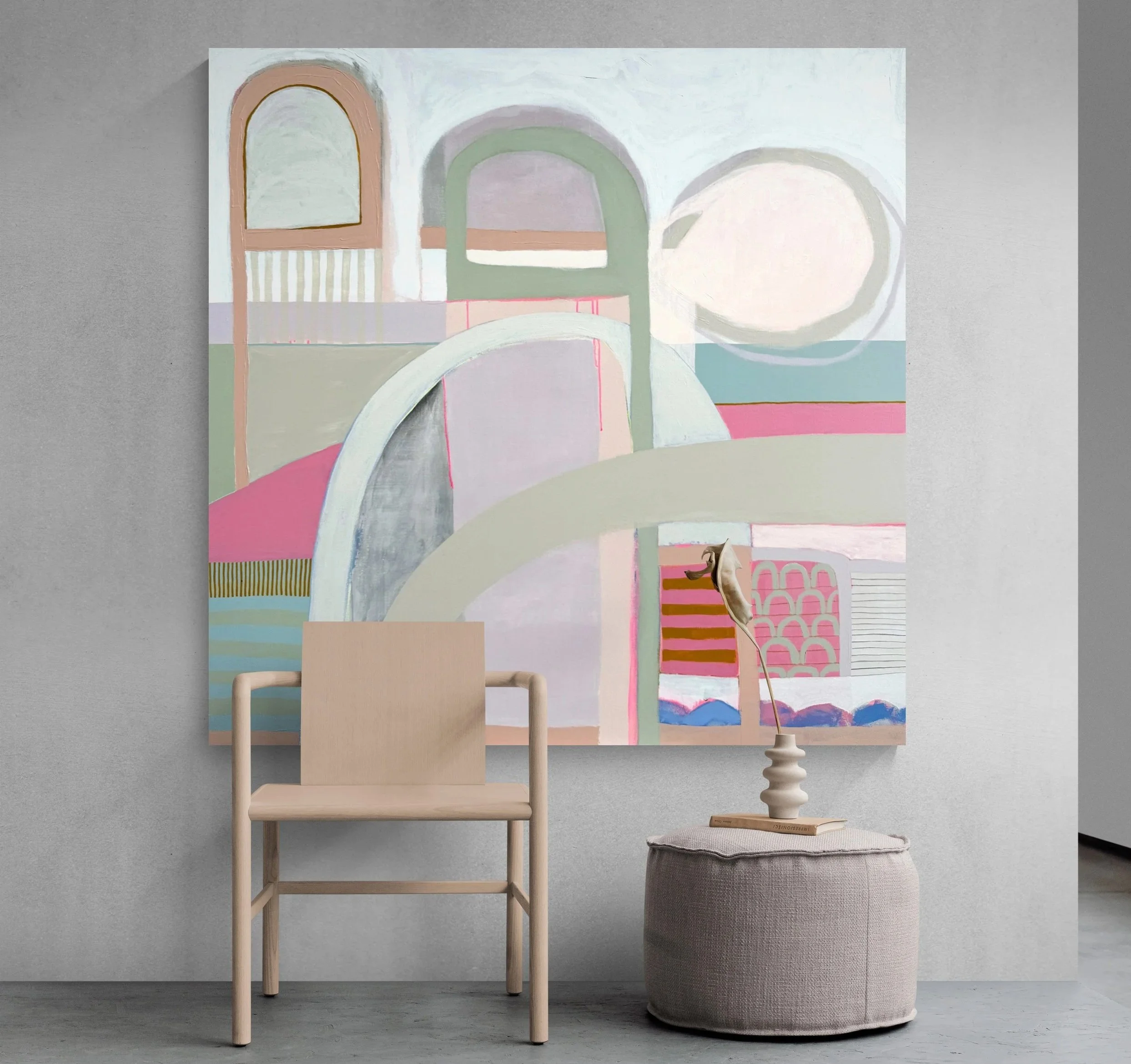 A modern interior scene featuring a light wood chair, a textured gray ottoman, and a large abstract pastel-colored painting with arches and geometric patterns on a gray wall.