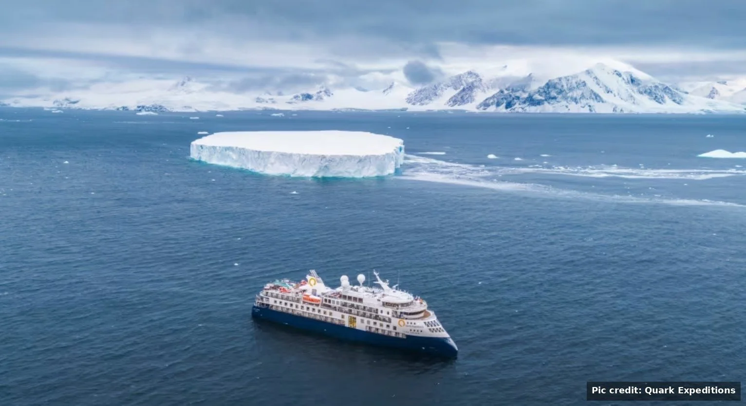 Quark Expedition ship sailing through Antarctic waters near icebergs