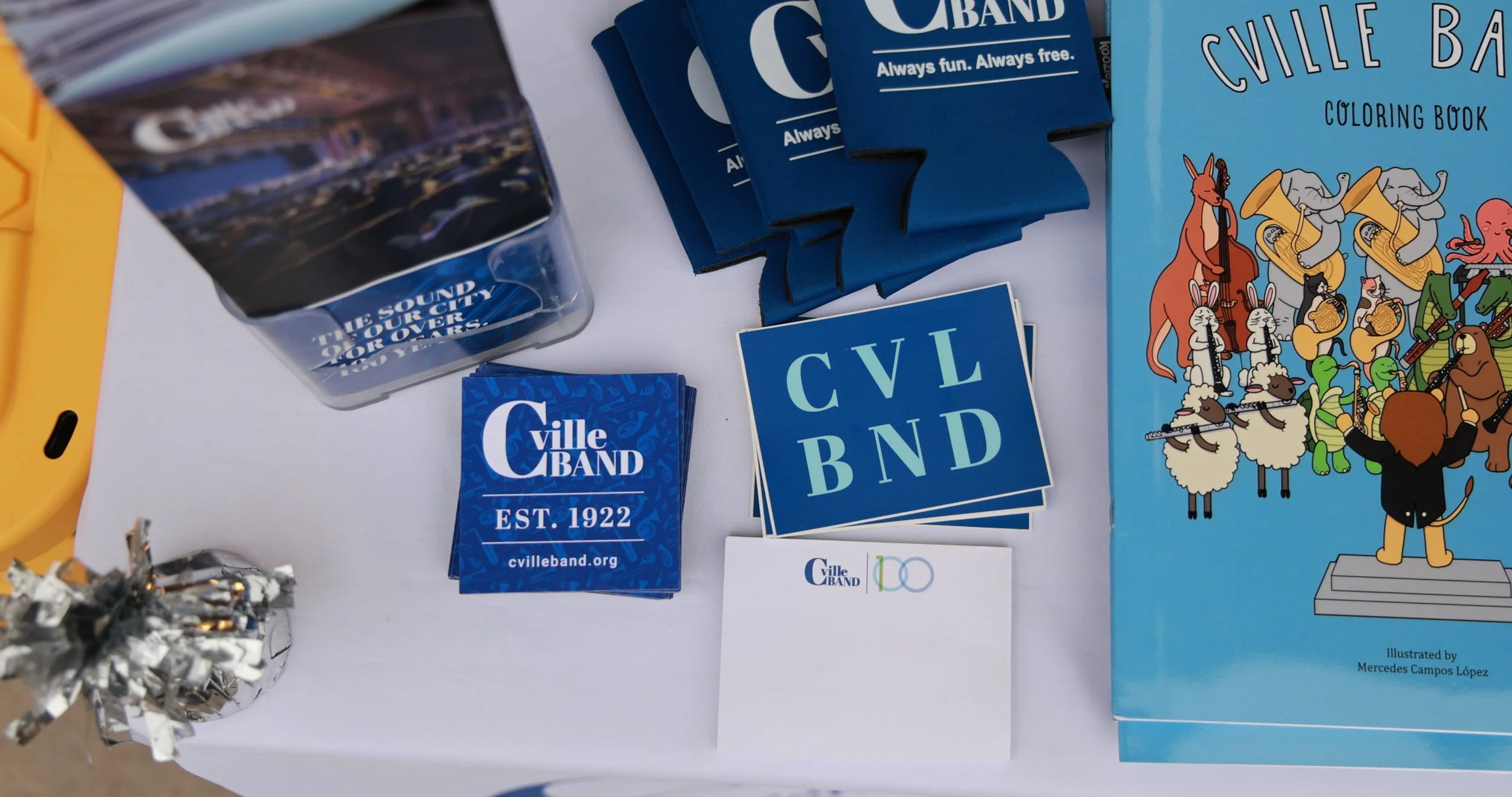 Table display with City Band promotional materials, including stickers, pamphlets, and coloring book featuring animated animals playing musical instruments.