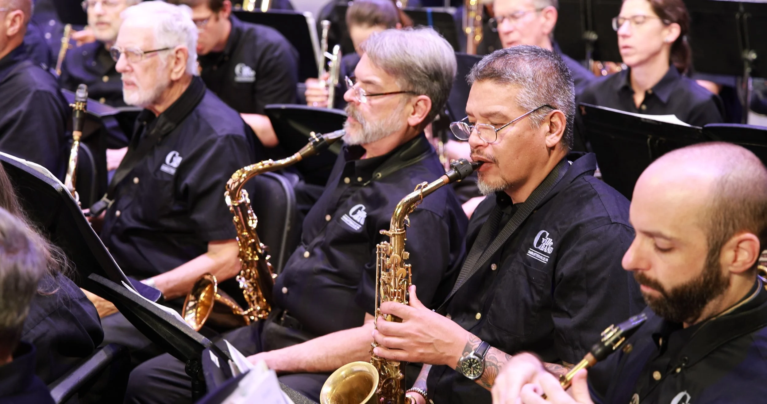 Members of a jazz band playing saxophones during a concert.