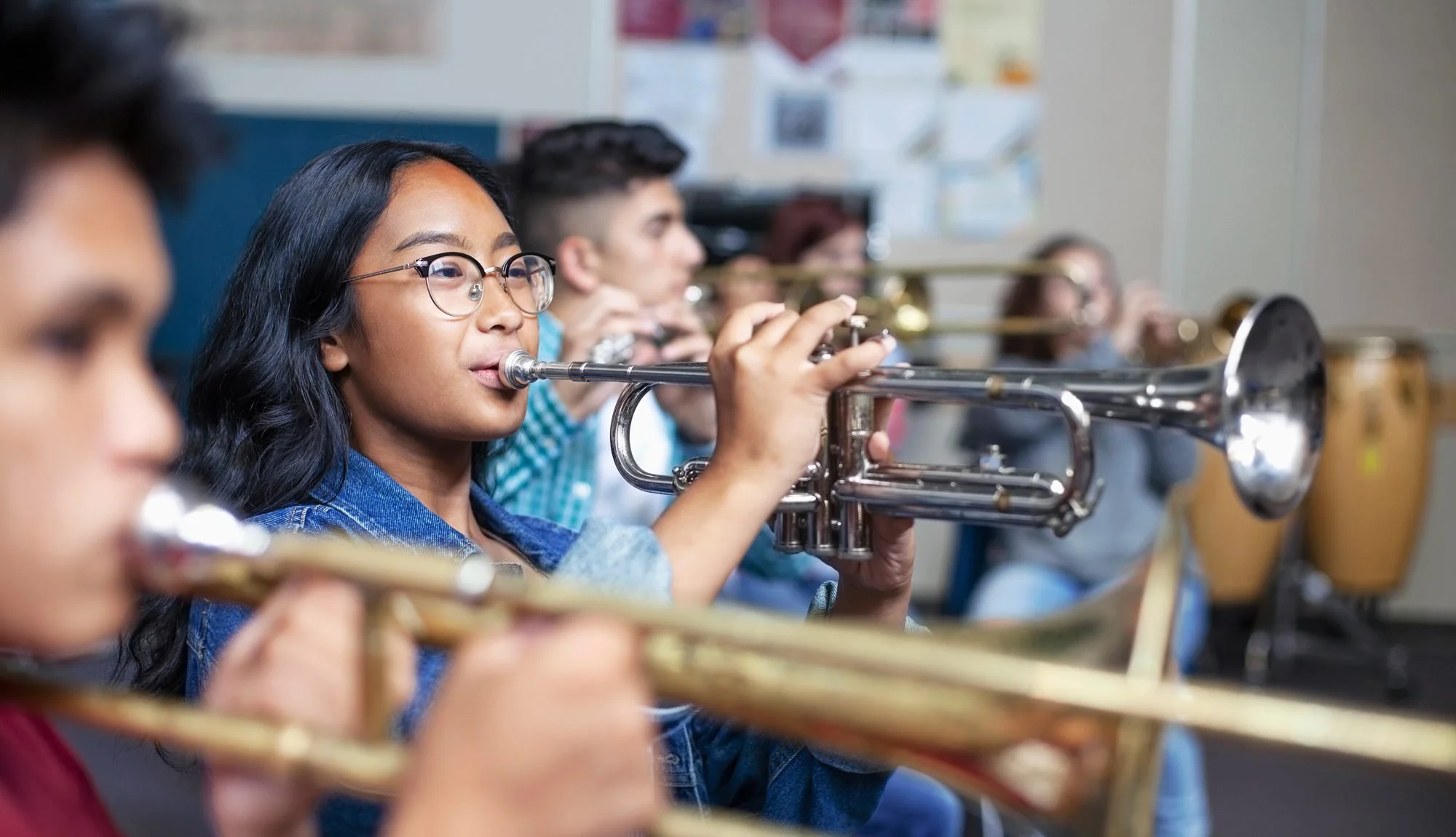 Students playing trumpets in a music classroom.