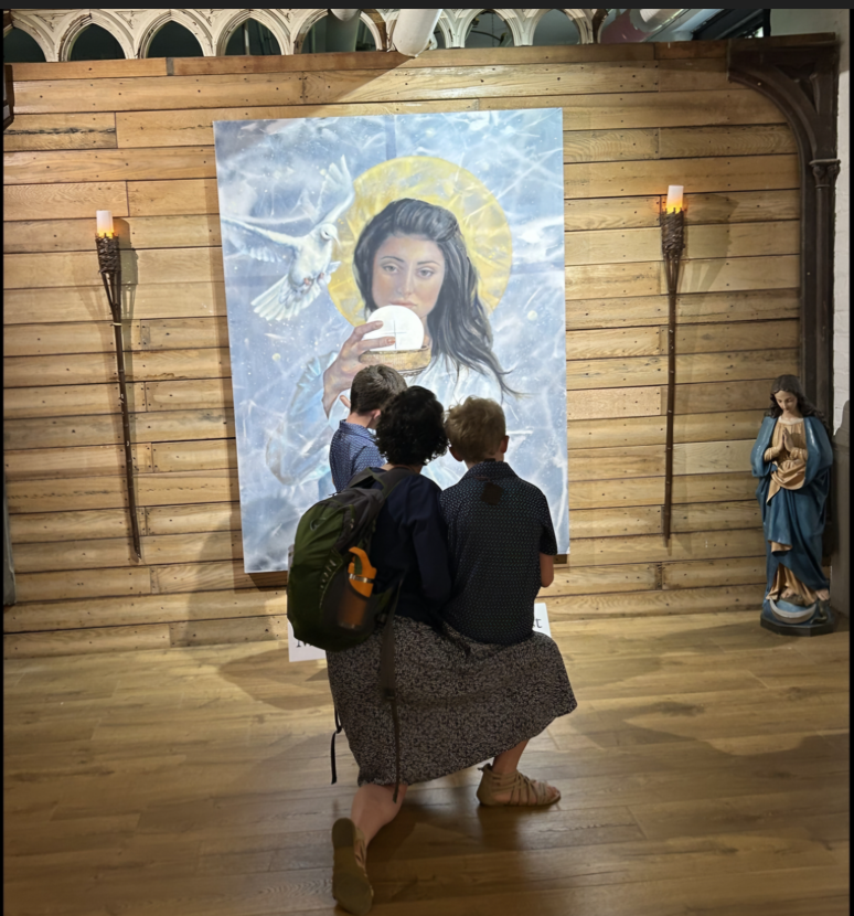 Women and children looking at a picture of the Blessed Virgin Mary