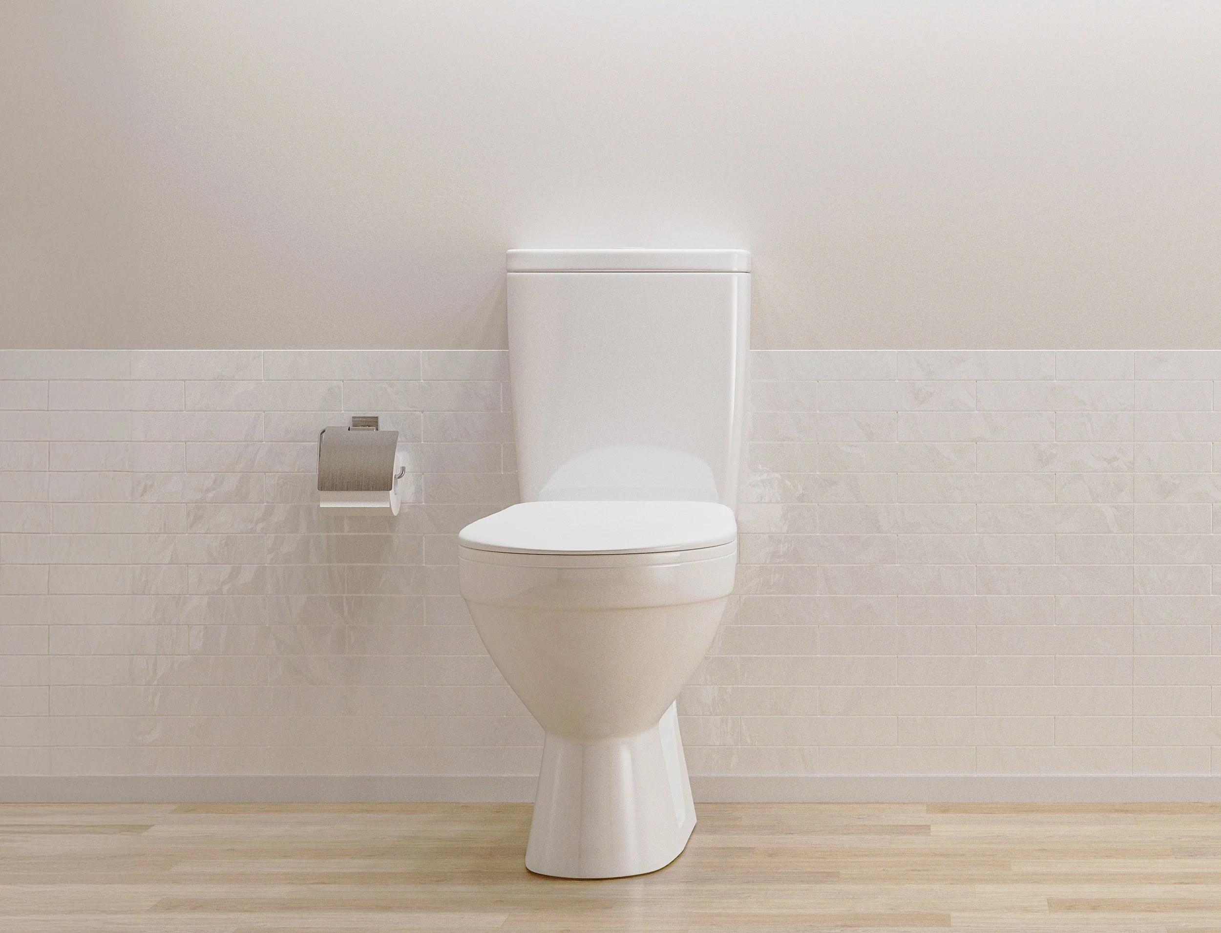 White toilet in a bathroom with a beige wall and wooden floor, with a toilet paper holder on the left.