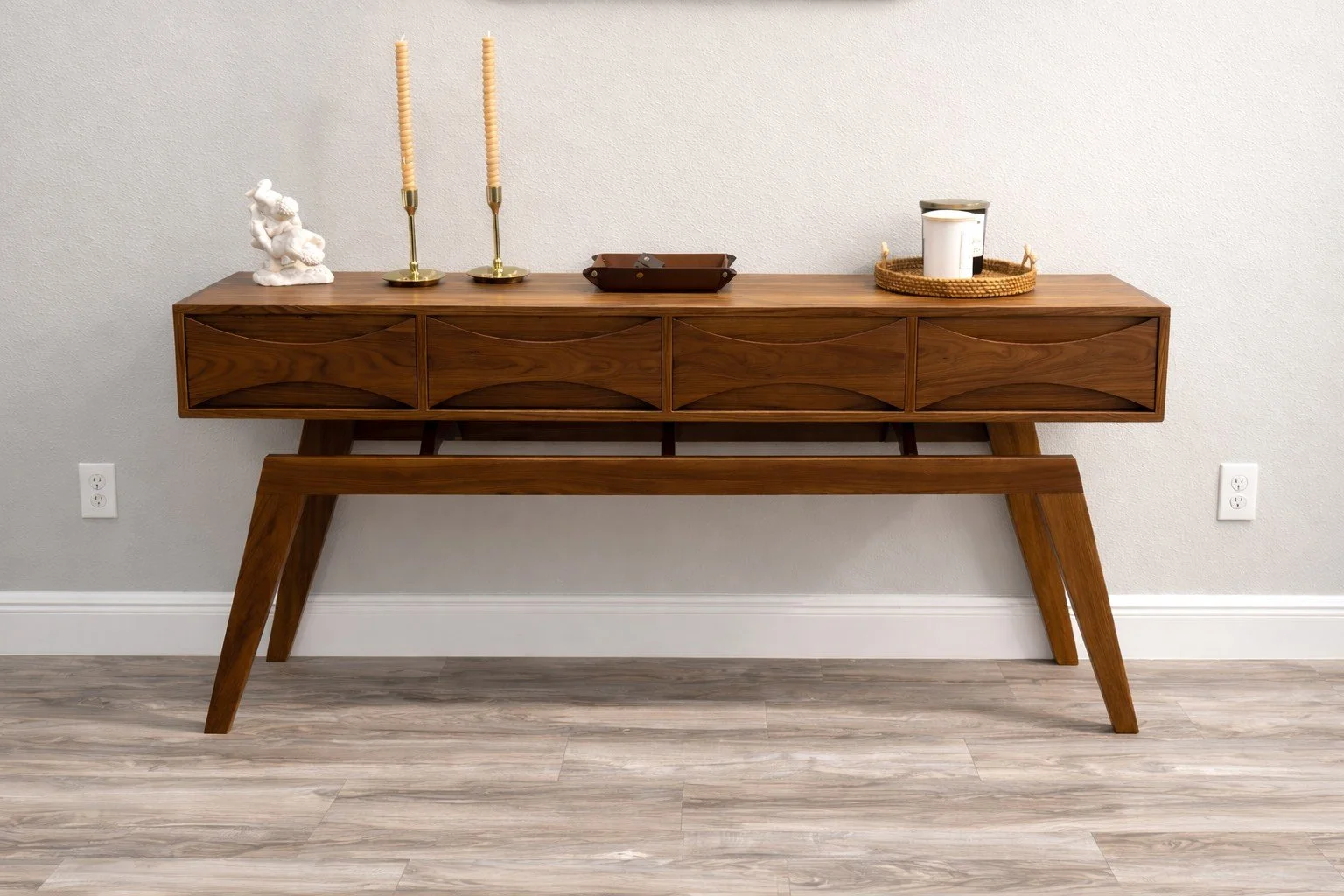 A walnut midcentury Modern entryway table with bowtie drawer fronts and splayed legs