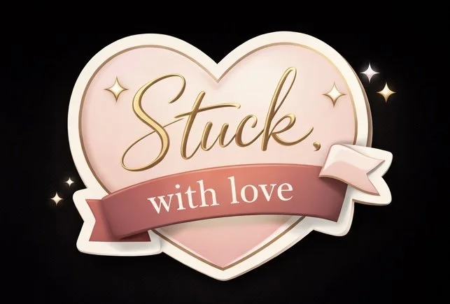 A pink heart-shaped sign with the words "Stuck with love" written in gold and white, decorated with small sparkles and a ribbon banner, against a black background.