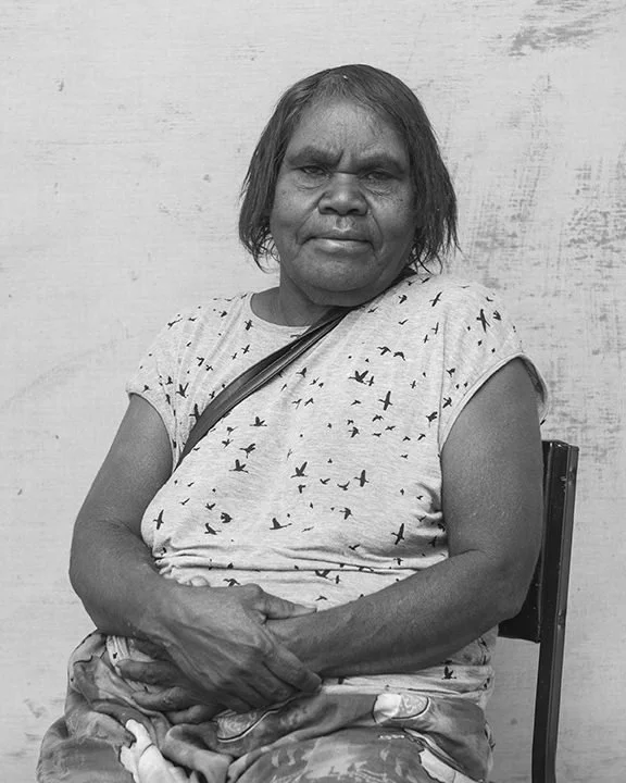 Black and white portrait of Indigenous woman with white background.