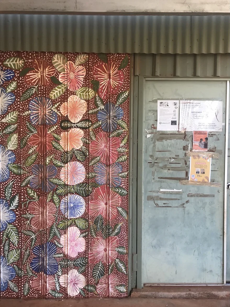 The doors to Artists of Ampilatwatja art centre, located approximately 325 km northeast of Alice Springs, are hand painted with flower and leaf motifs.