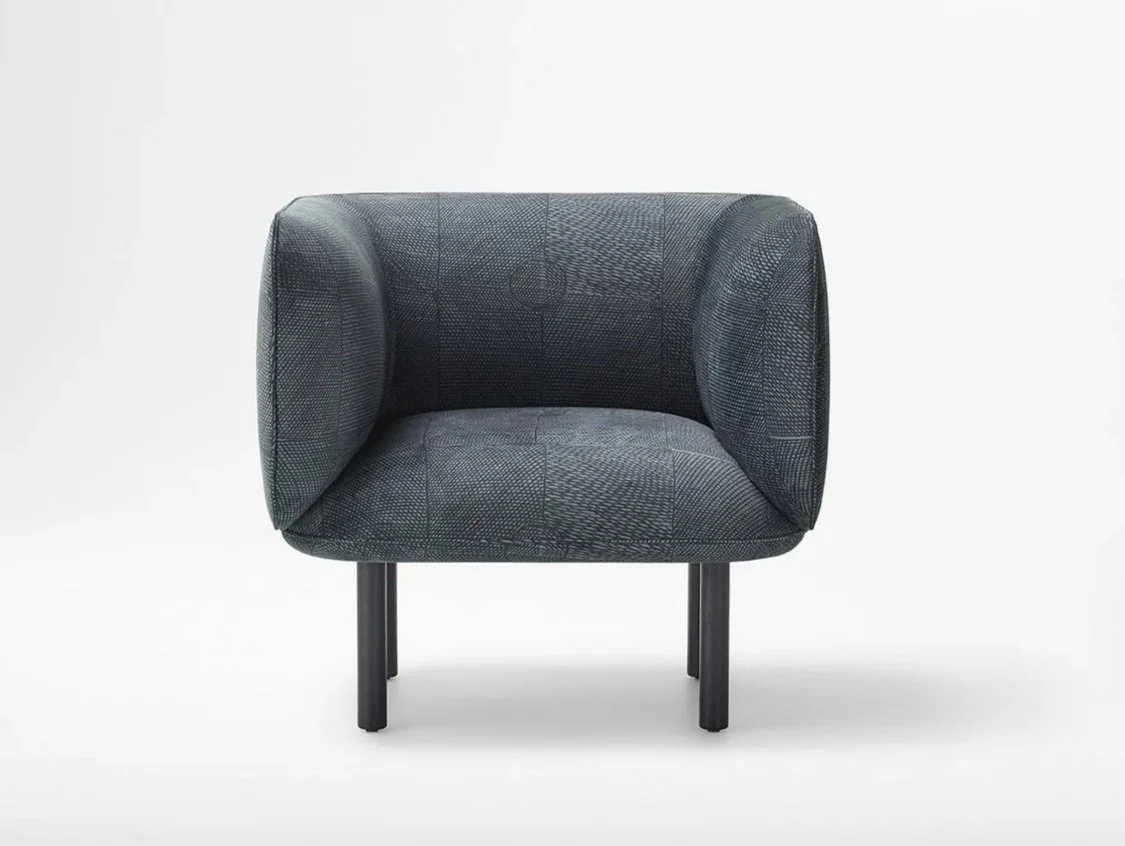 Upholstered chair in white space featuring First Nations design in black and grey