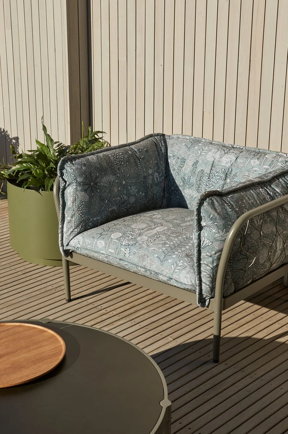 Outdoor armchair upholstered in Willie Weston Sugarbag Dreaming ‘Ghost Gum’ design, a bold floral artwork by First Nations artist Rosie Ngwarraye Ross from Ampilatwatja, NT.