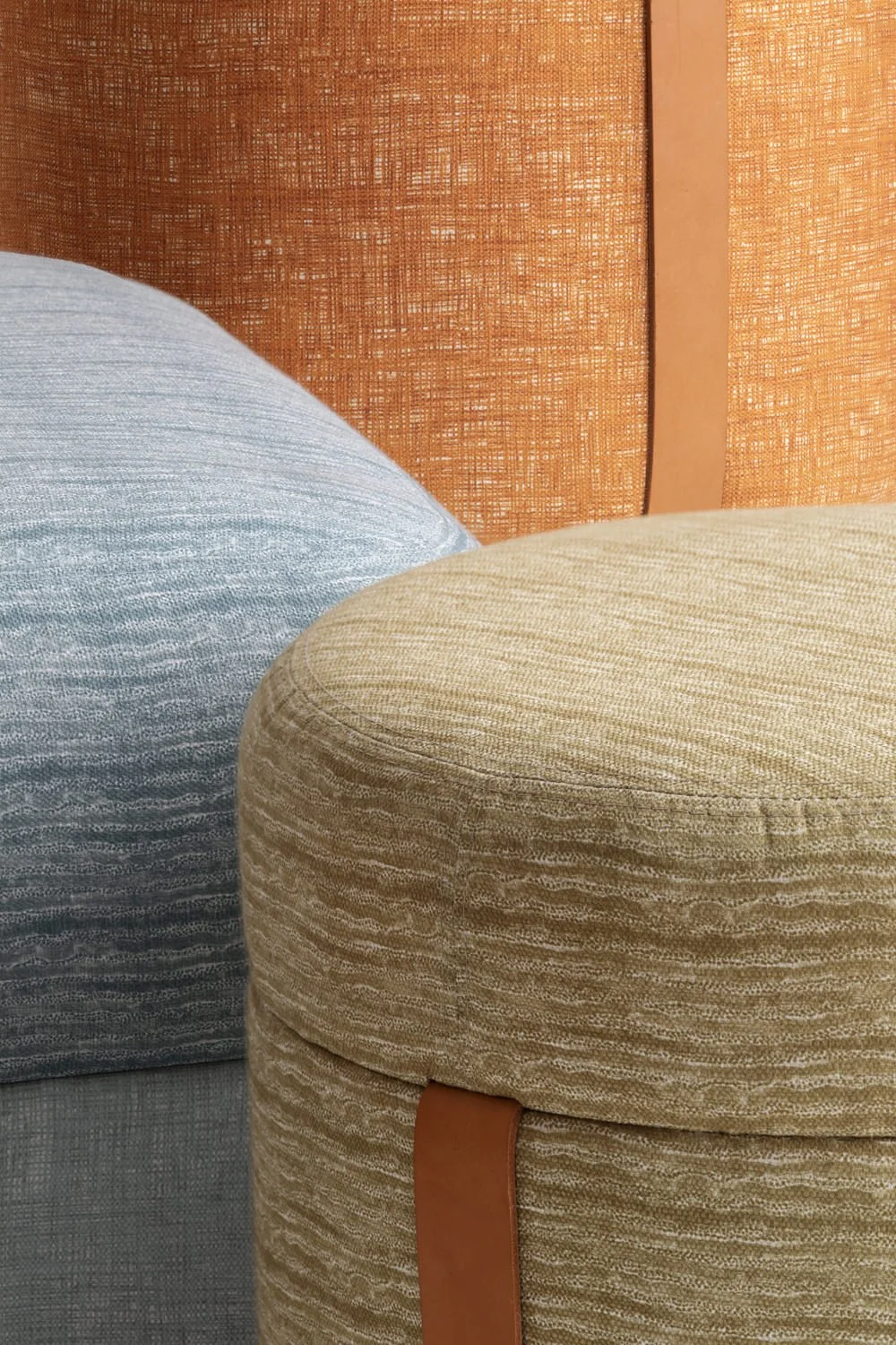 Close up view of three ottomans upholstered in vibrant, blue, orange and gold patterned fabrics.