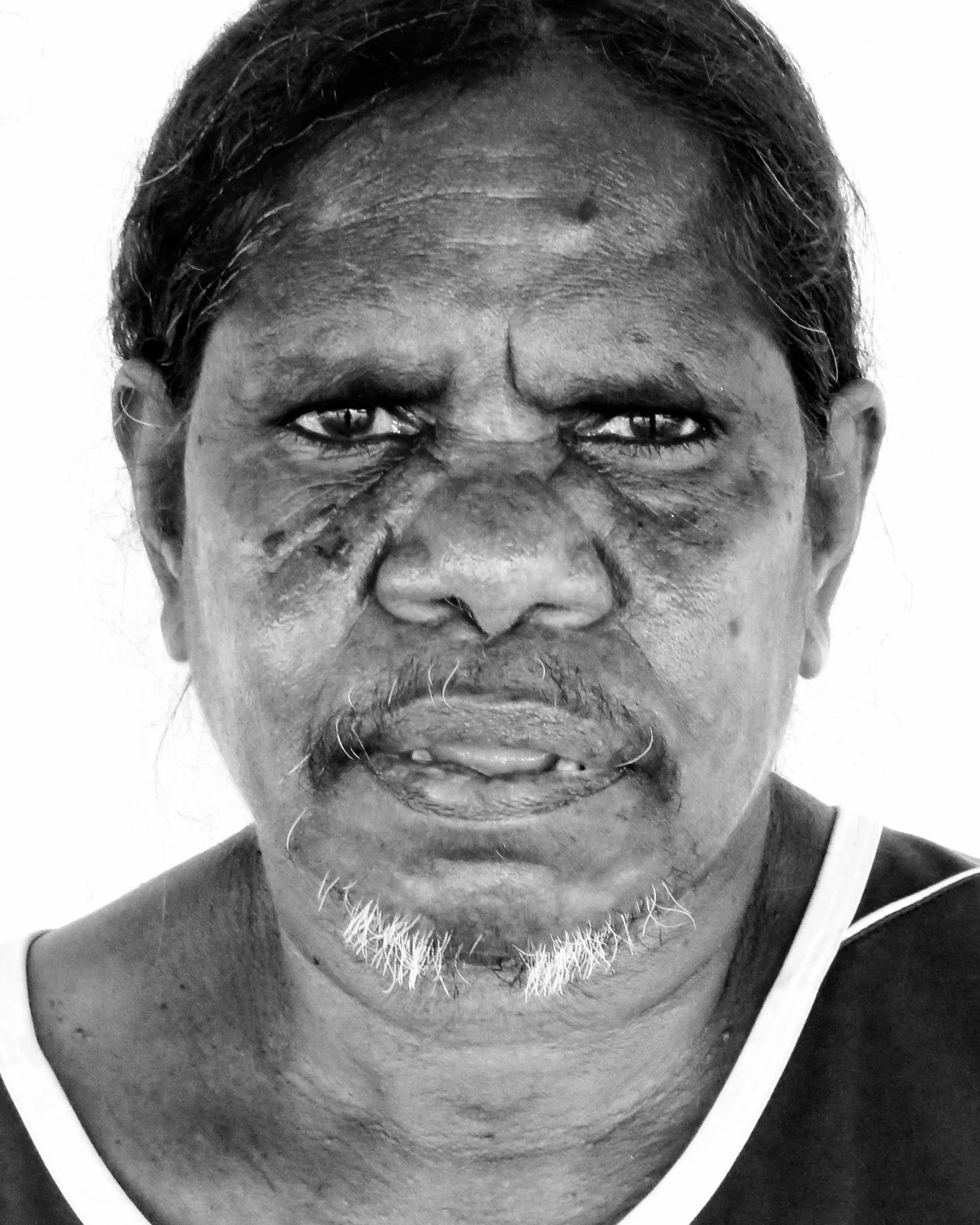 Black and white portrait of an Indigenous woman with a white background.