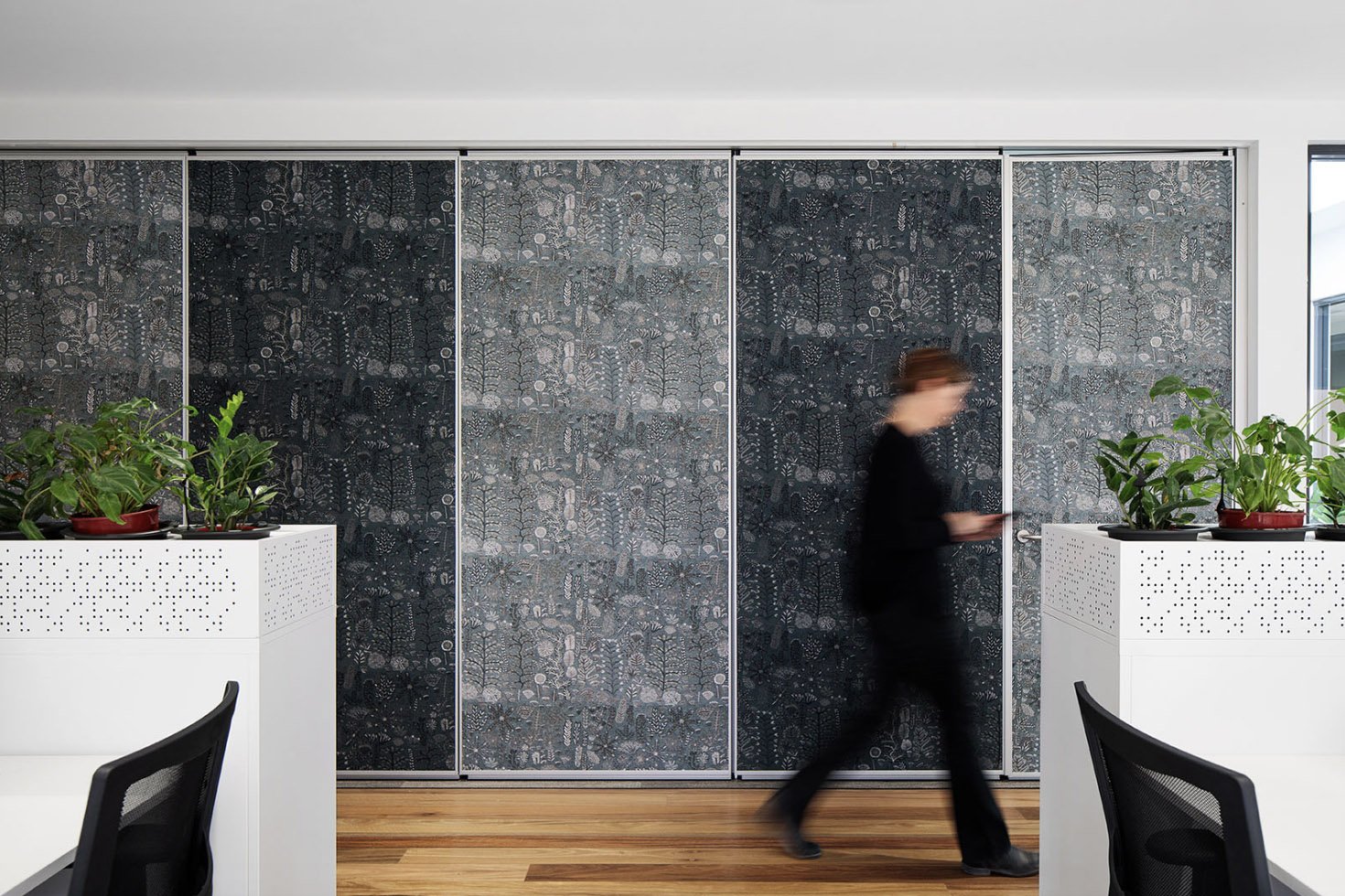 Operable walling upholstered in Willie Weston Sugarbag Dreaming ‘Ghost Gum’ design, a bold floral artwork by First Nations artist Rosie Ngwarraye Ross from Ampilatwatja, NT.