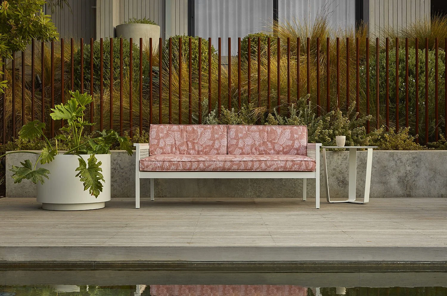 Outdoor sofa upholstered in Willie Weston Rainbows 'Pindan', a delicately patterned contemporary Aboriginal artwork by First Nations artist April Jones from the Kimberley, WA.