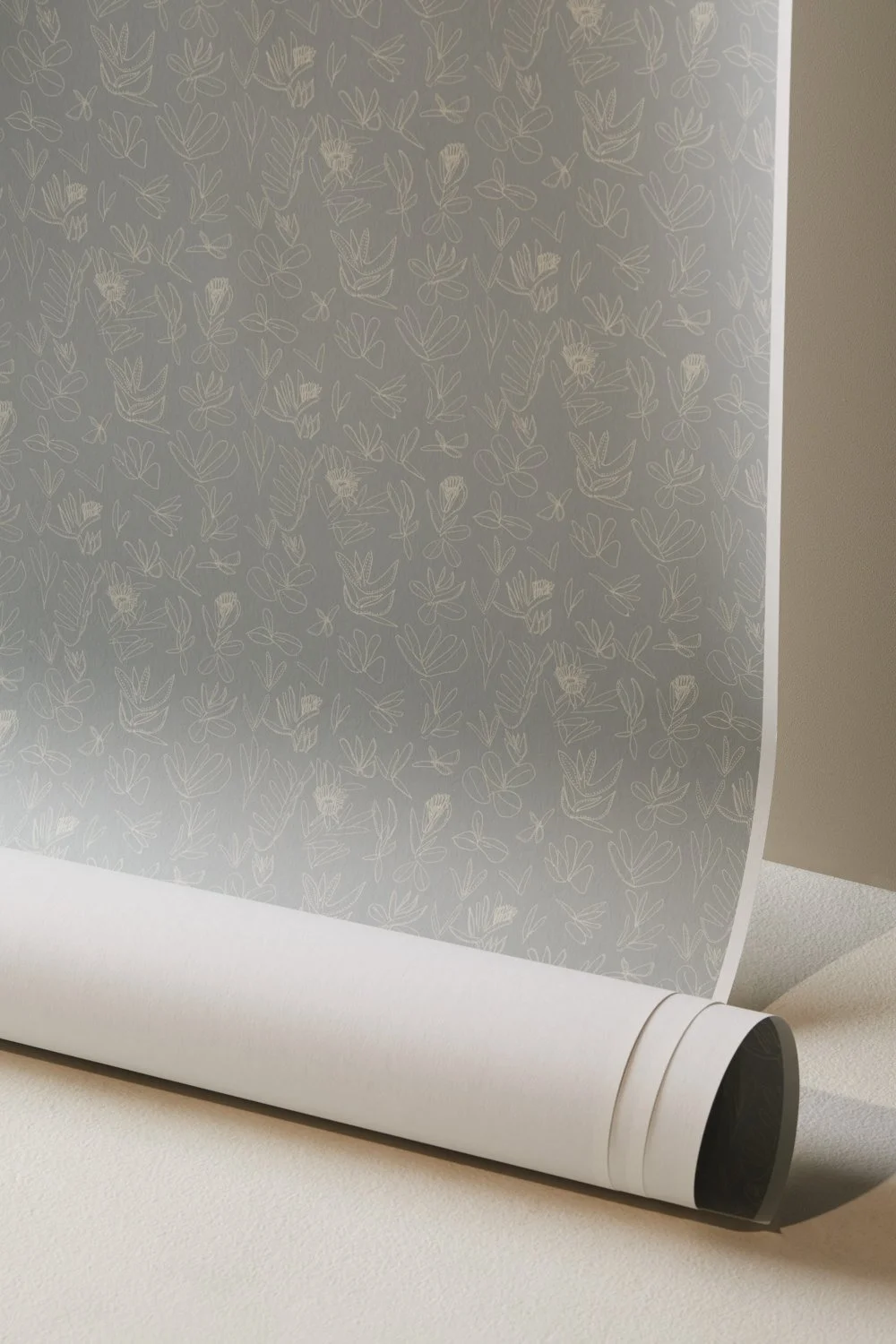 Wallpaper unrolled from top printed with First Nations design, blue with white flowers