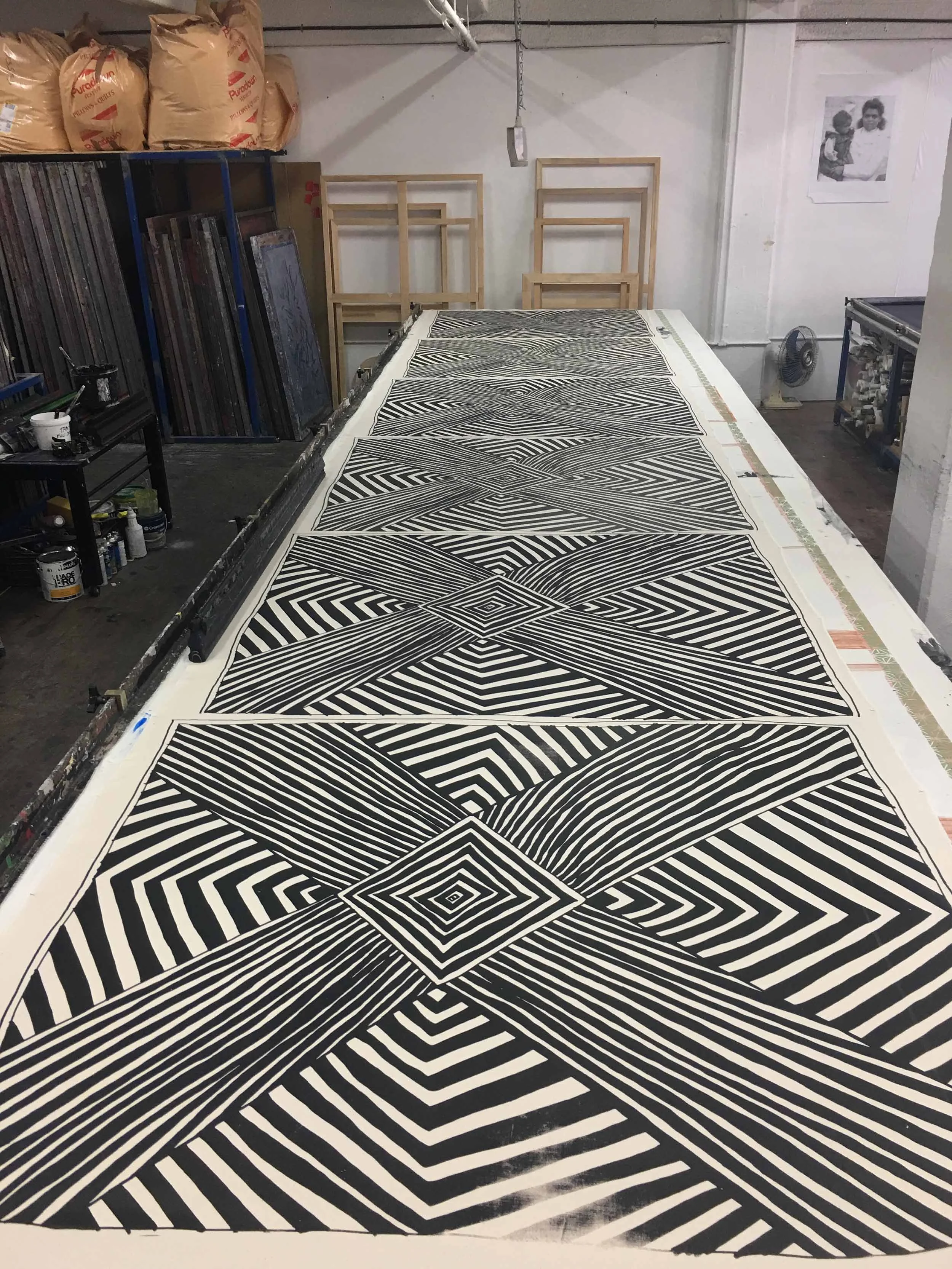 A screen printing table displaying a black and white geometric design repeated down the length of the table.