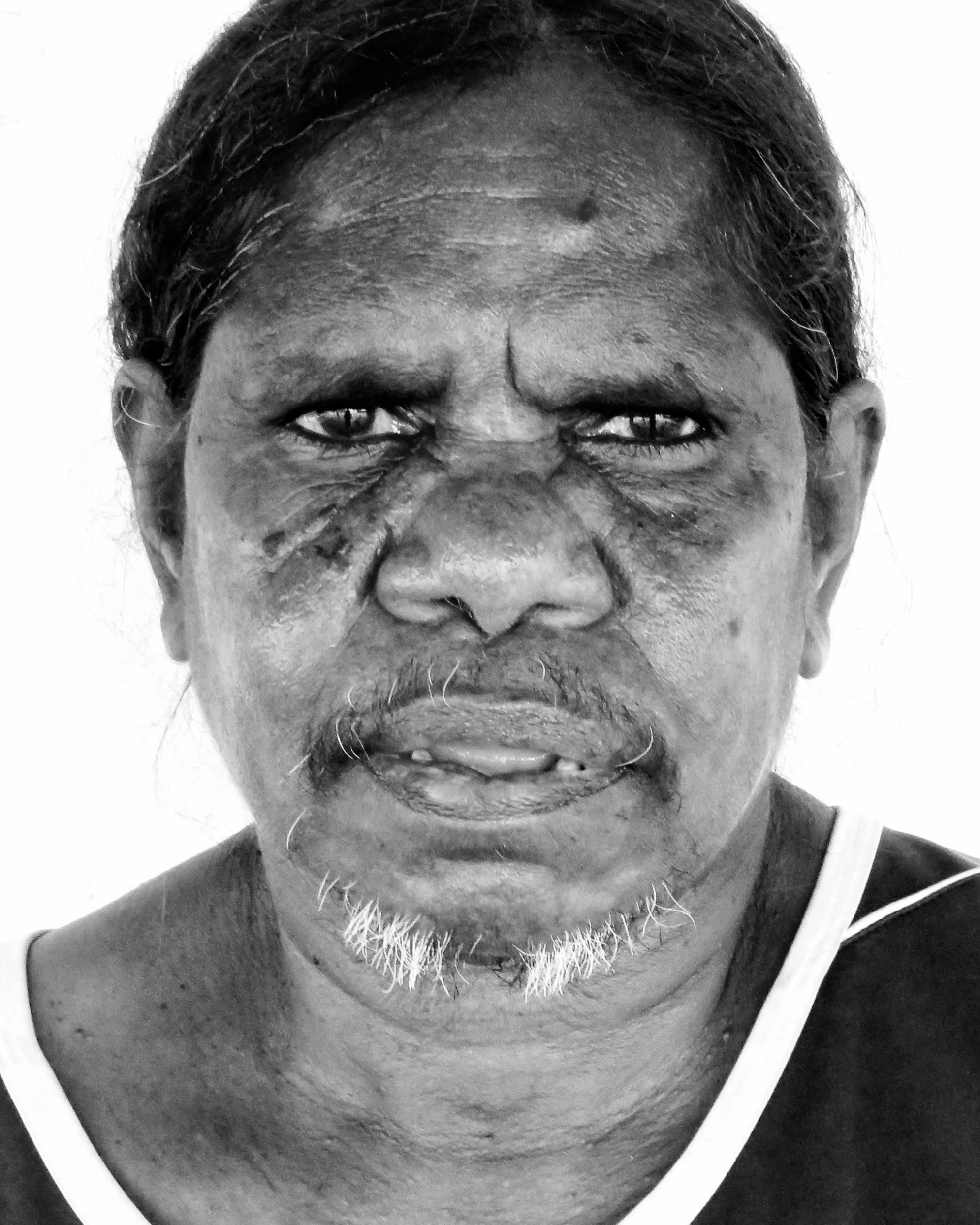Black and white portrait of an Indigenous woman with a white background.