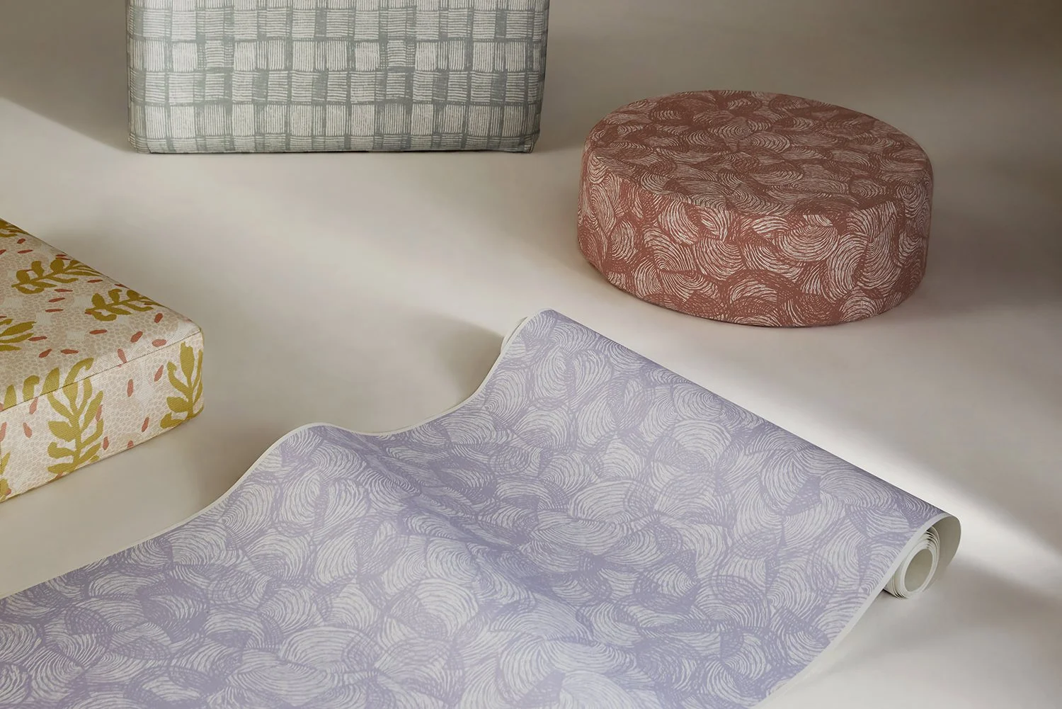 Wallpaper in foreground and ottomans upholstered in Willie Weston designs featuring contemporary Aboriginal designs by First Nations artists from the Kimberley, WA.