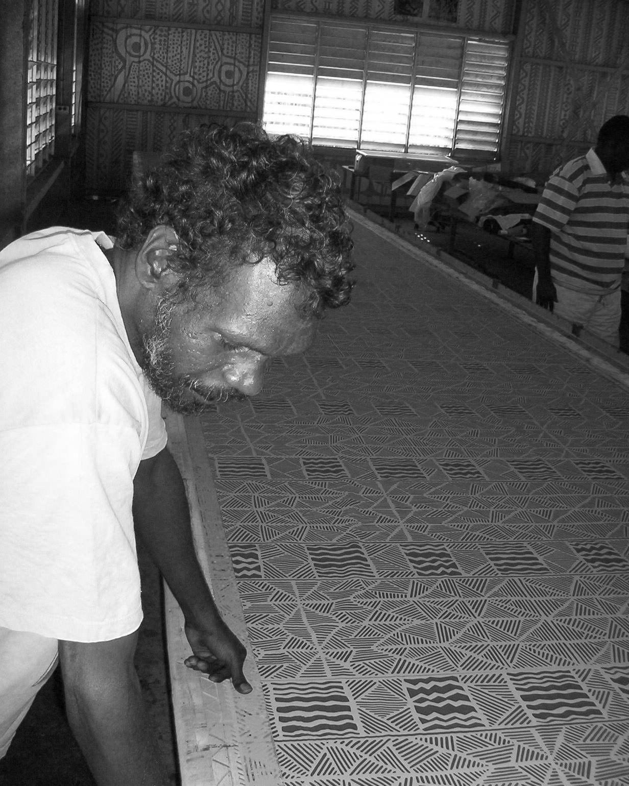 Black and white portrait of an Indigenous man working in a screen printing studio.