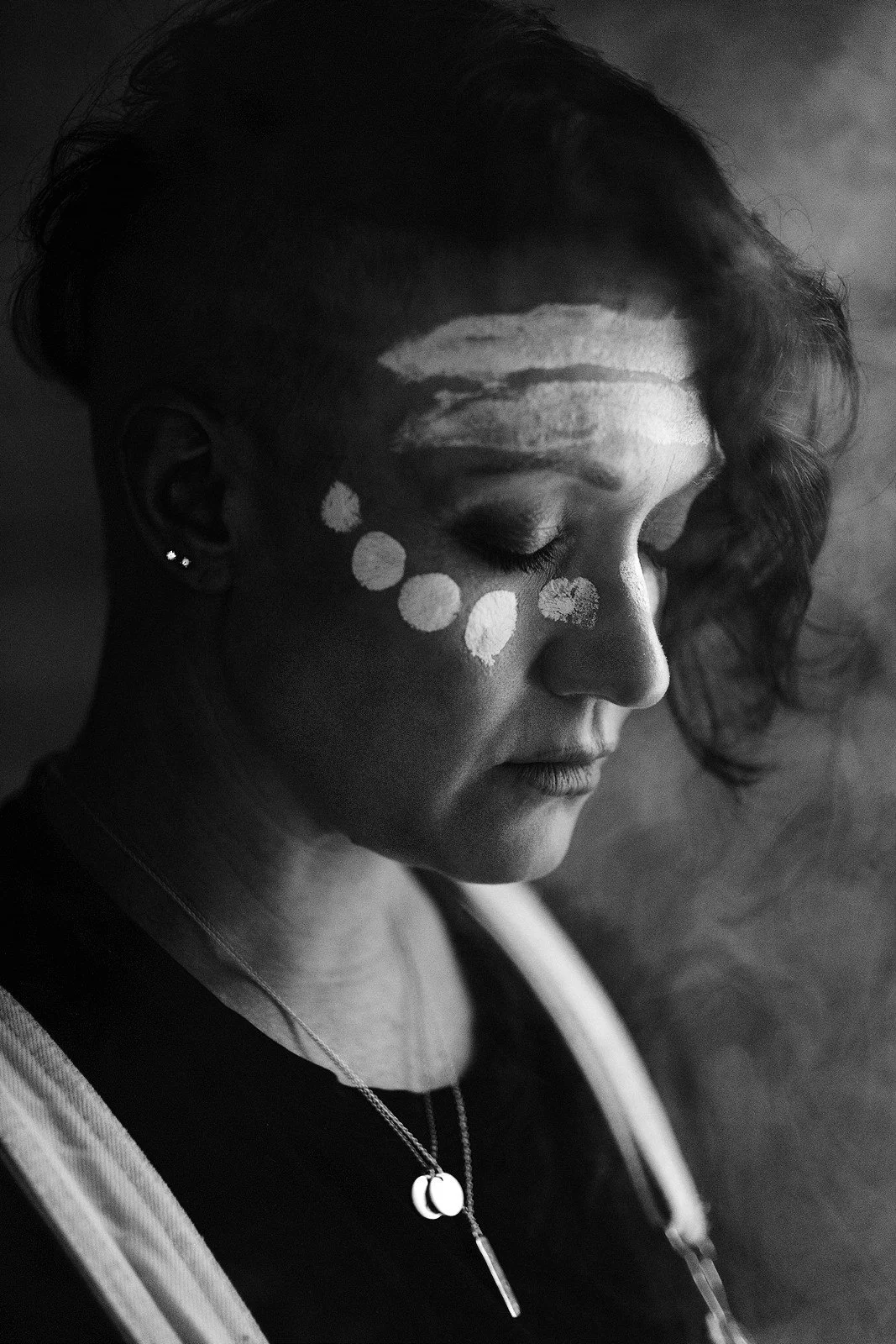 Black and white portrait of an Indigenous woman with a grey background.