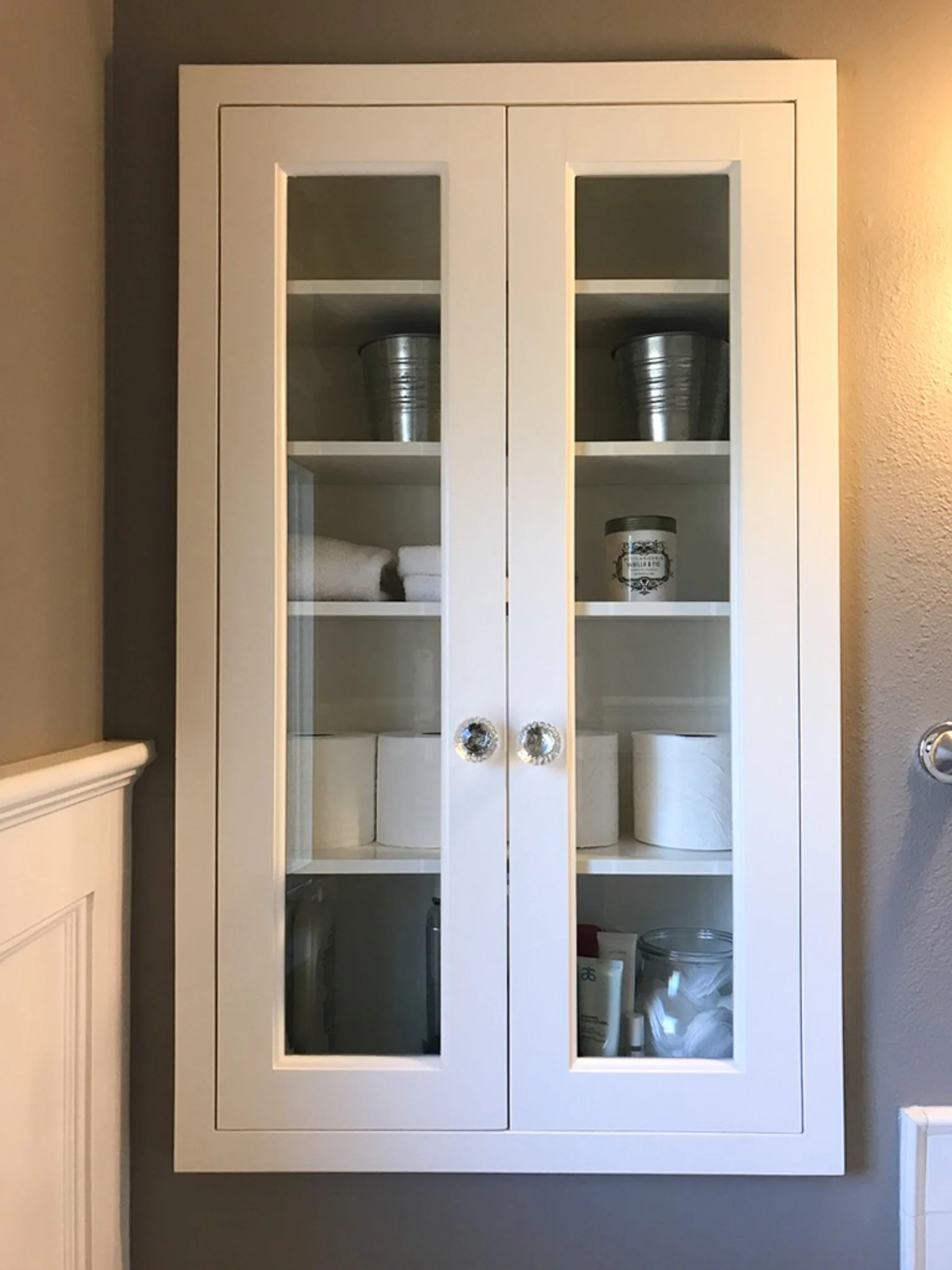 Building the medicine cabinet with slim windowed doors added to the transitional feel of the bathroom, providing needed organization and storage shelves without taking up space.