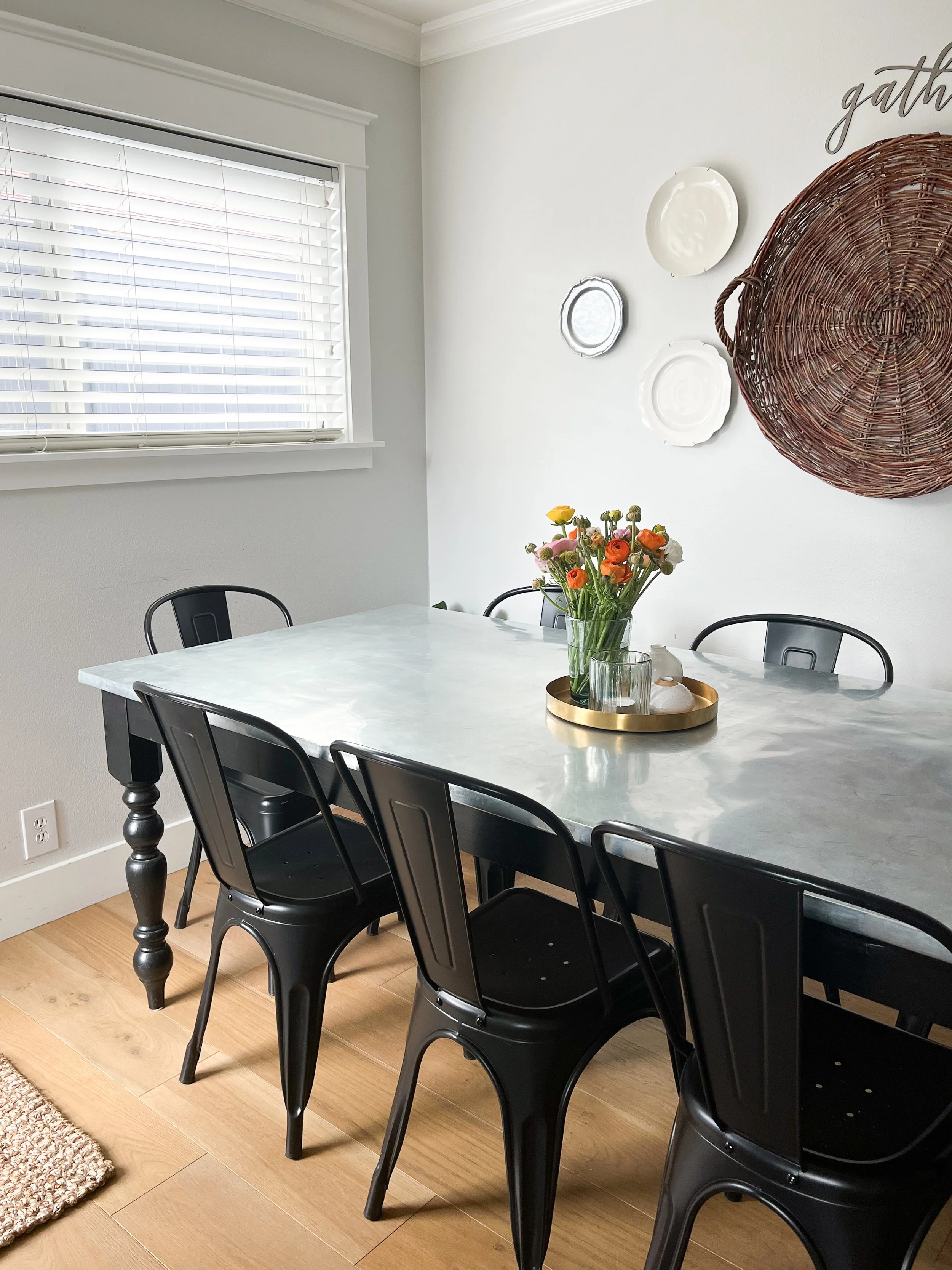The zinc top table was designed and created to expand seating for up to 10 in this dining room.  It's shiny black painted legs and skirt add contrast and grounding to the light metal surface.  It's functional and easy to clean as well as unique and b