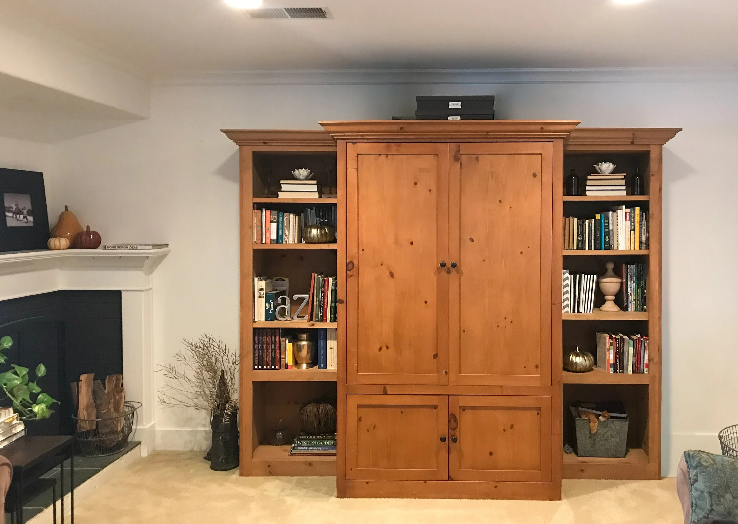 This armoire and bookshelf served as a focal point alongside creating storage and display space in this small living room.