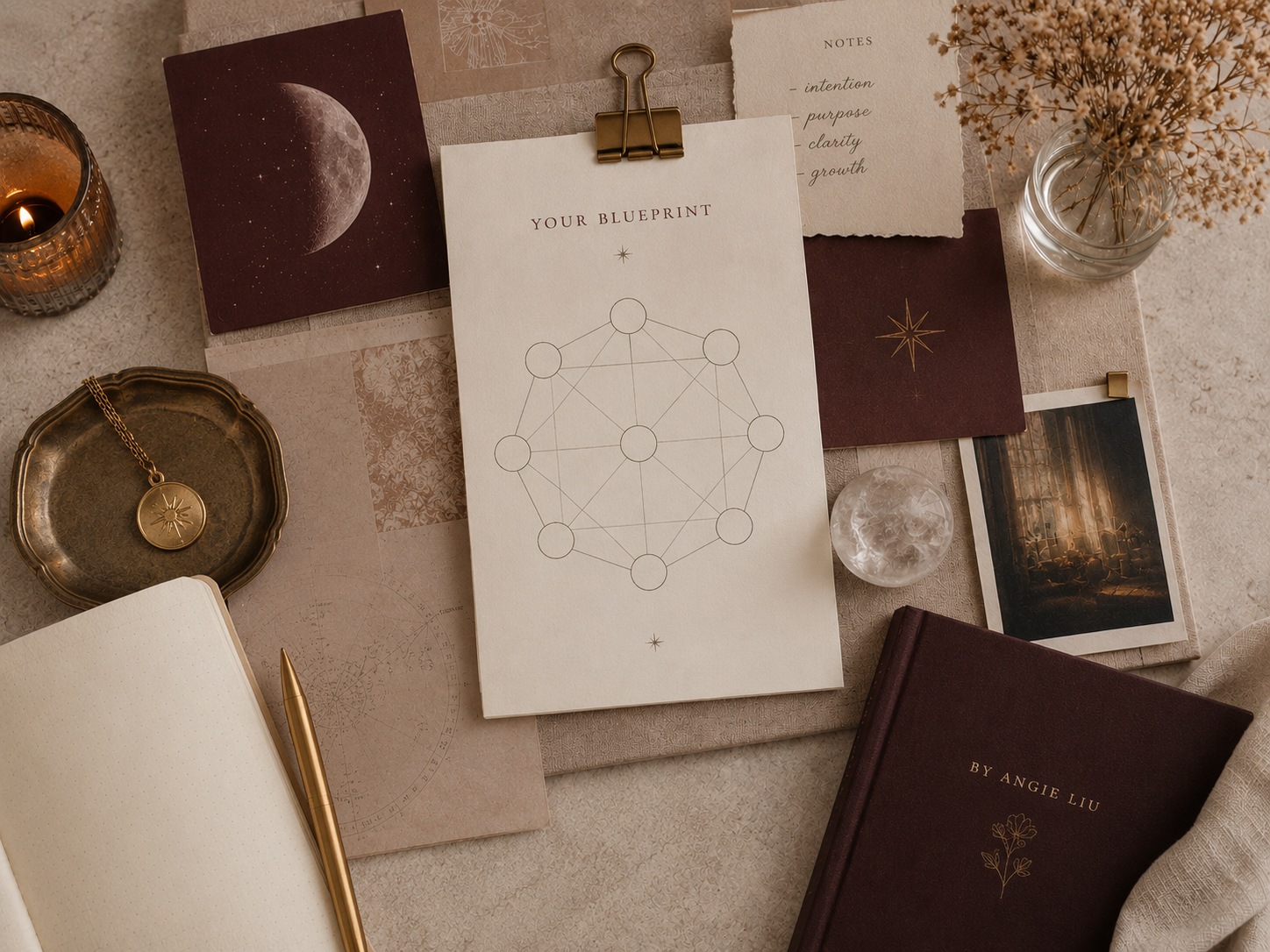 Flat lay of a desk with astrology-themed items including a notebook, a gold pen, a necklace with a sun and moon pendant in a small tray, a printed blueprint with geometric design, a candle, a photo of a cityscape, notes with written points, a jar with dried flowers, and decorative paper with celestial motifs.
