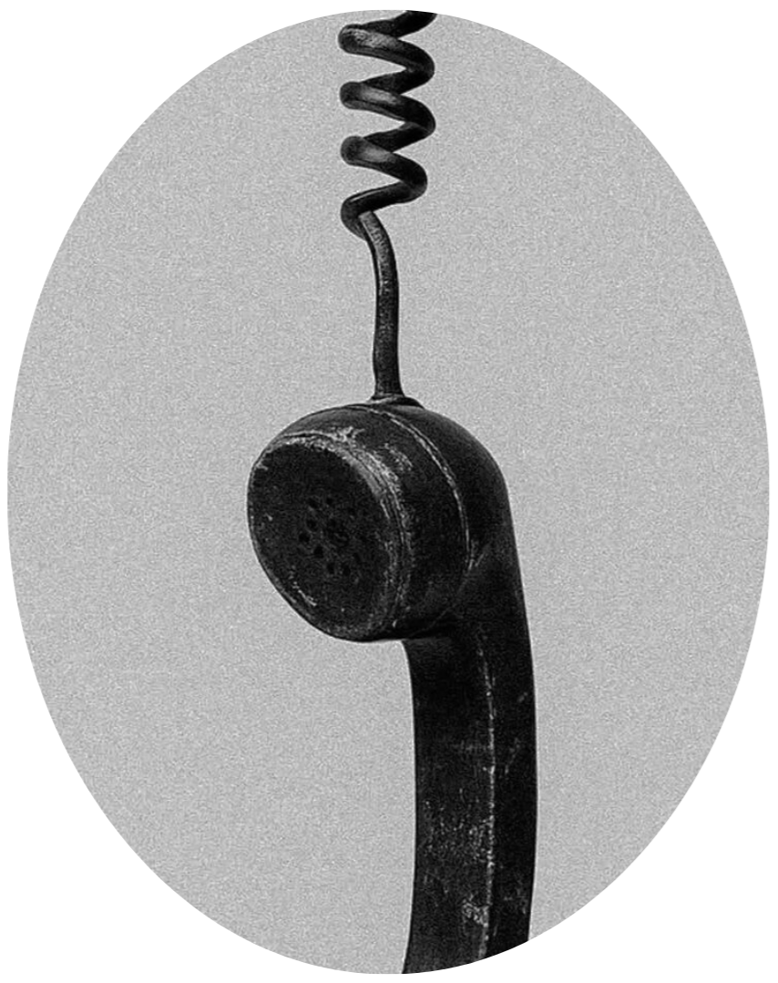 A black and white photo of an old-fashioned telephone receiver hanging