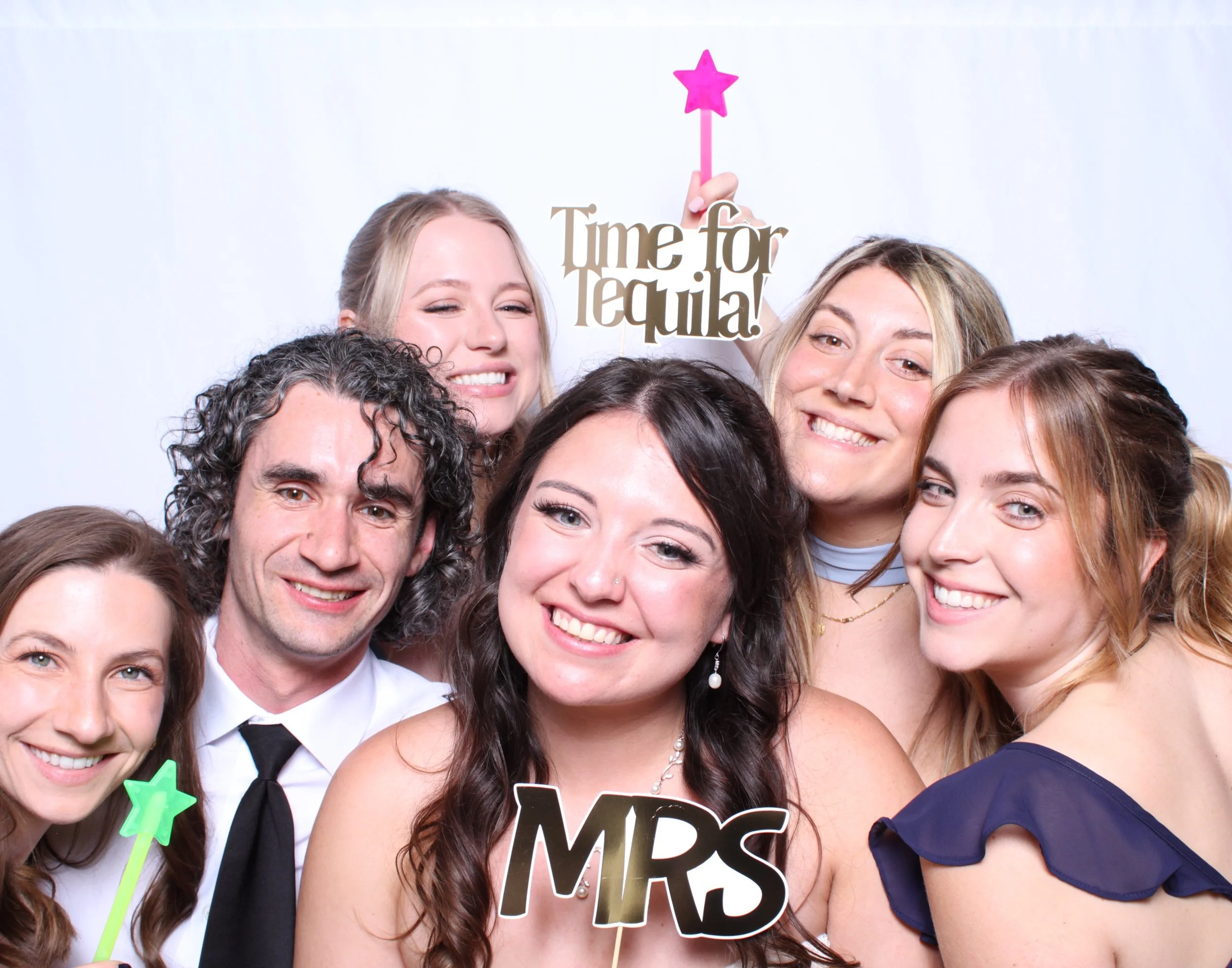 A bride and groom taking a photo with friends at the photobooth they hired for their wedding in Toronto.