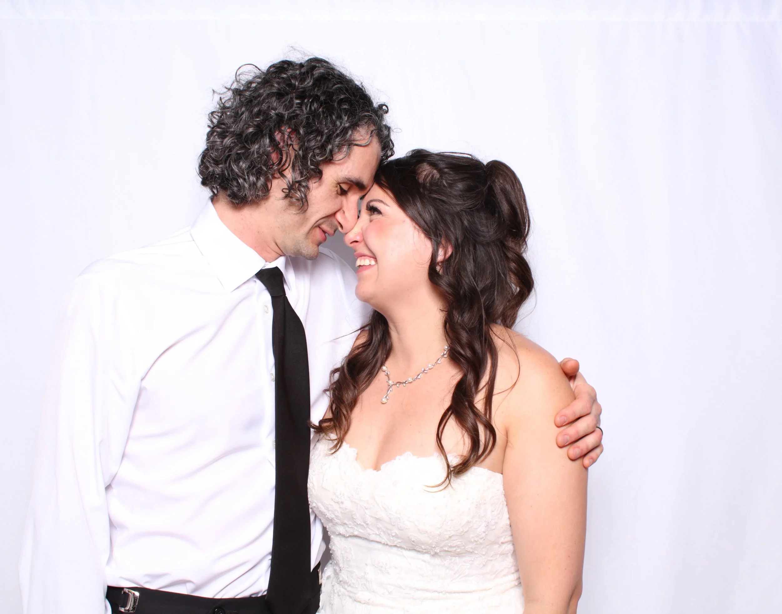 Bride and Groom taking a stunning wedding day photo at their Wedding Photobooth that they rented from Insta Prints Photobooth Rentals.