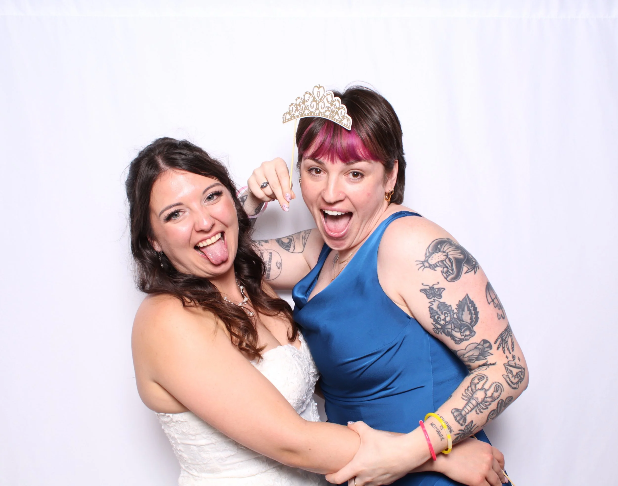 A Bride at her Toronto wedding Photobooth taking a silly photo with a brides maid.