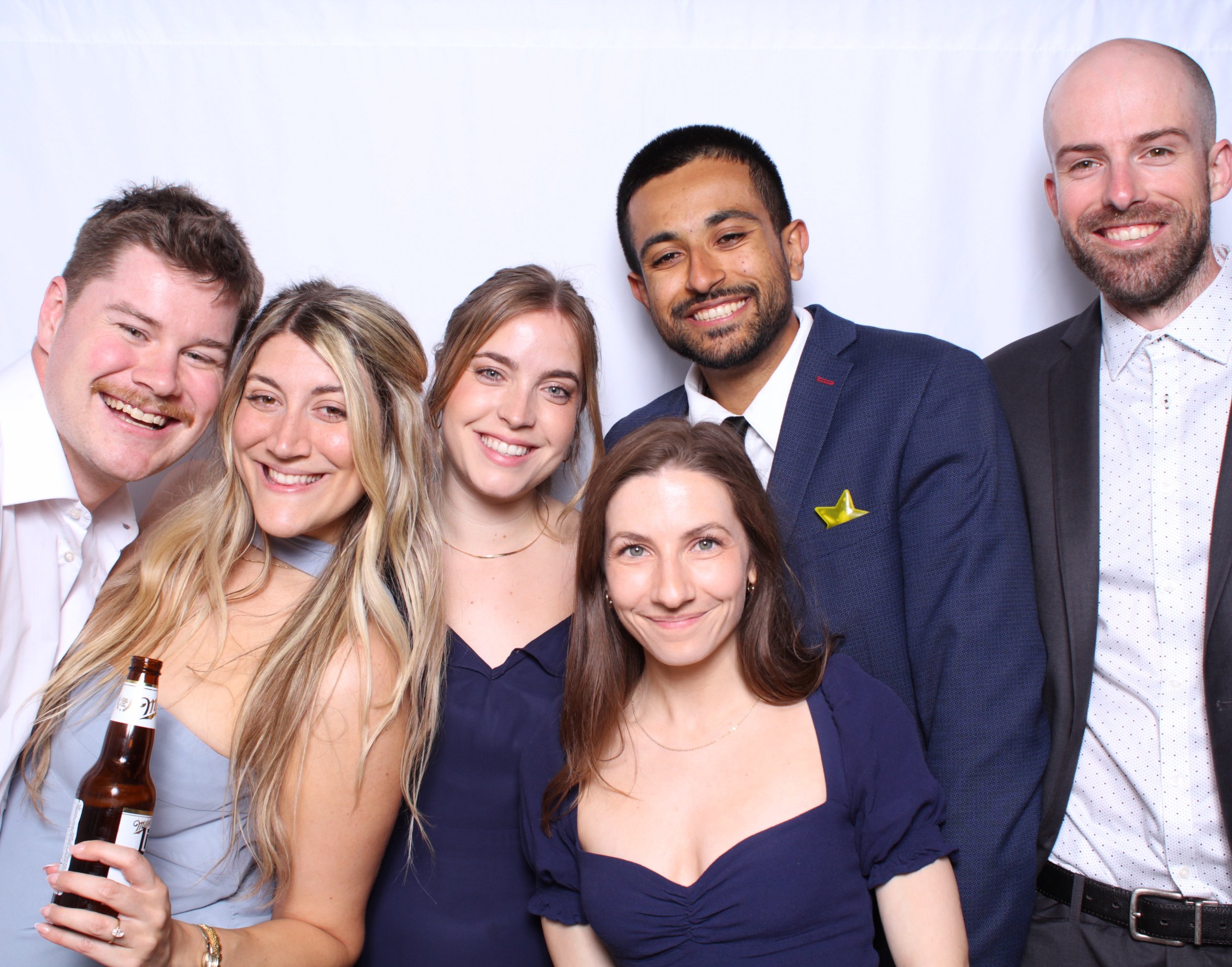 Friends taking a group photo at their friends wedding photobooth in Toronto.