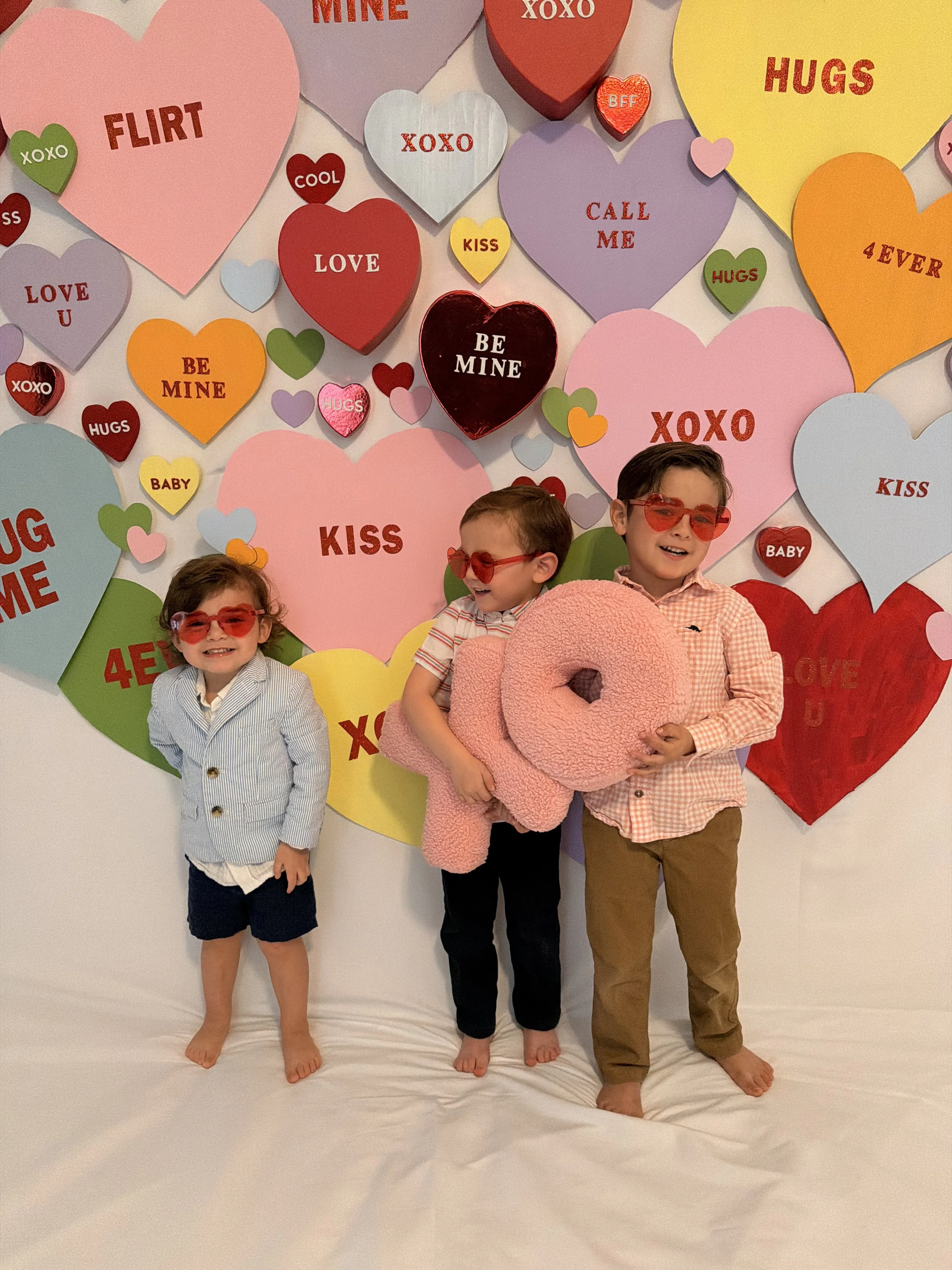 Valentine’s Day themed in-home photo studio with white backdrop, hearts, and professional lighting