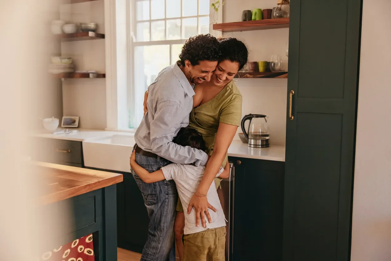 Family embracing in the kitchen of their new home