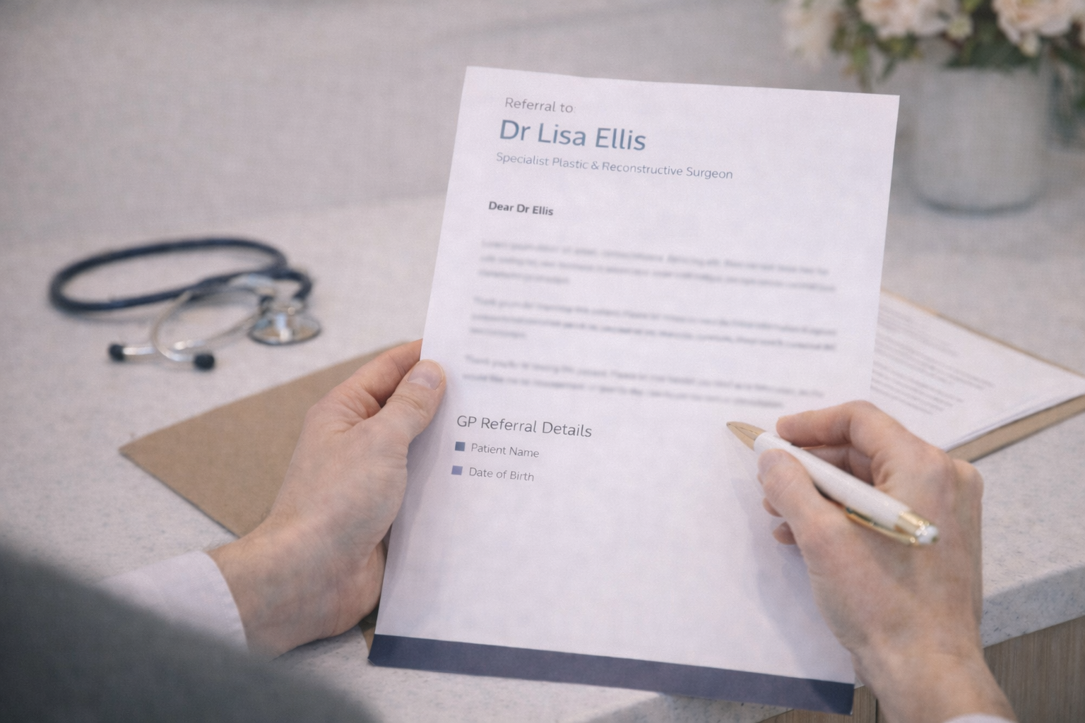 A person holding a medical referral letter with a stethoscope on the table nearby.