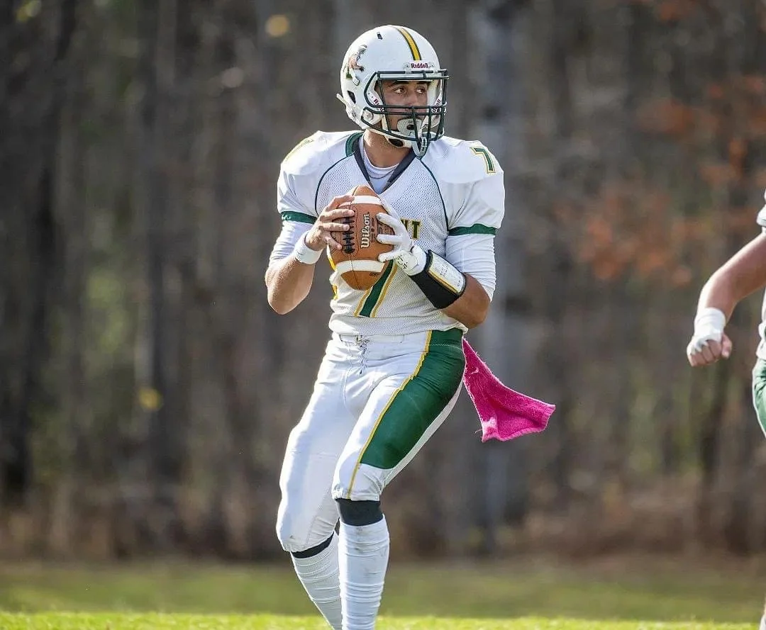 Javen Sears playing quarterback and team captain for the University of Vermont Club Football team, dropping back to pass.